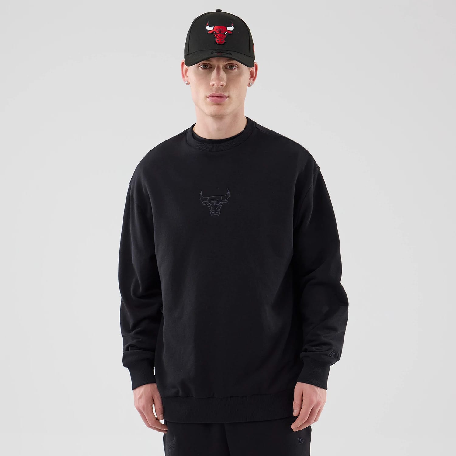 The model is wearing this NBA League Essential Chicago Bulls Oversized Crew Neck Sweater in black. 1
