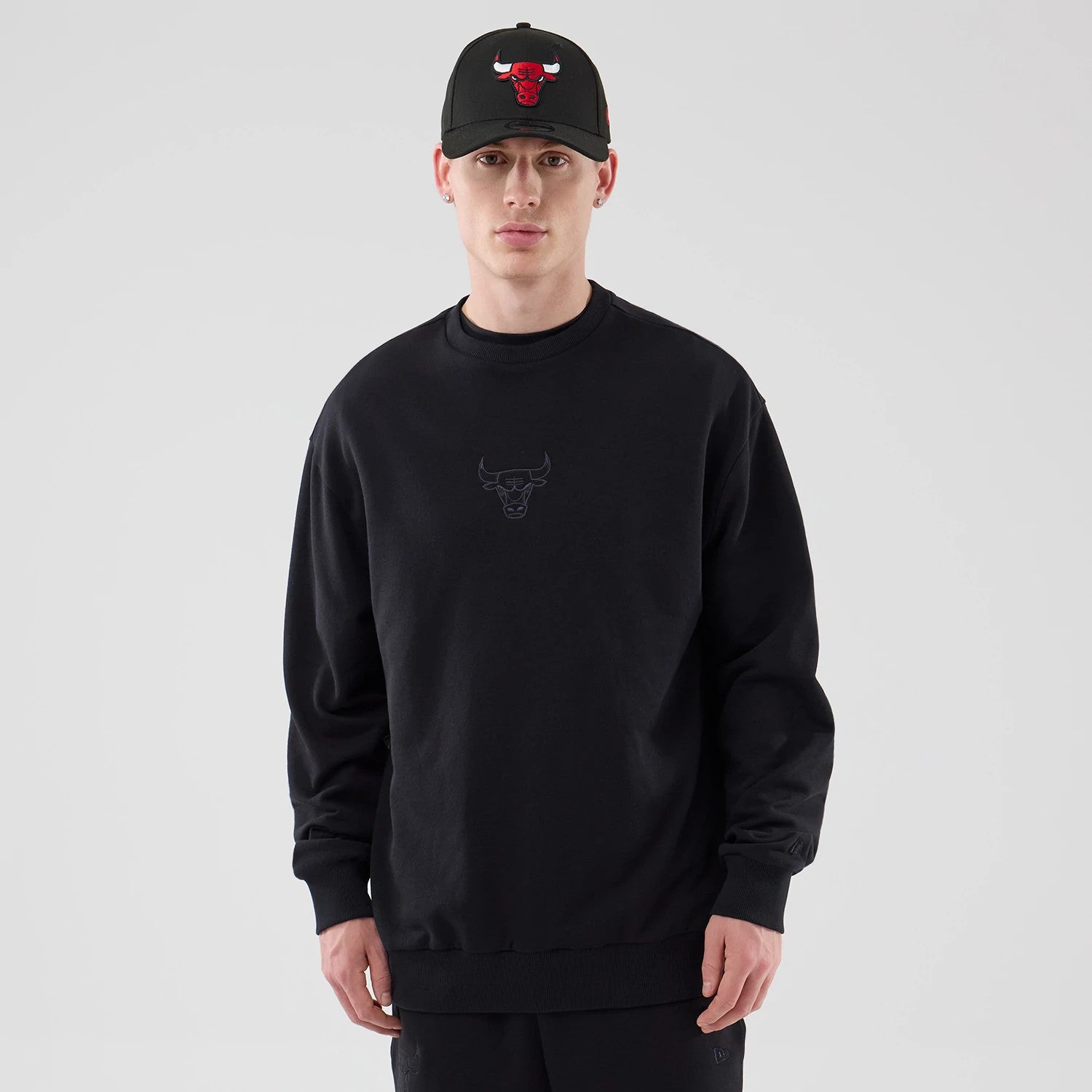 The model is wearing this NBA League Essential Chicago Bulls Oversized Crew Neck Sweater in black. 1