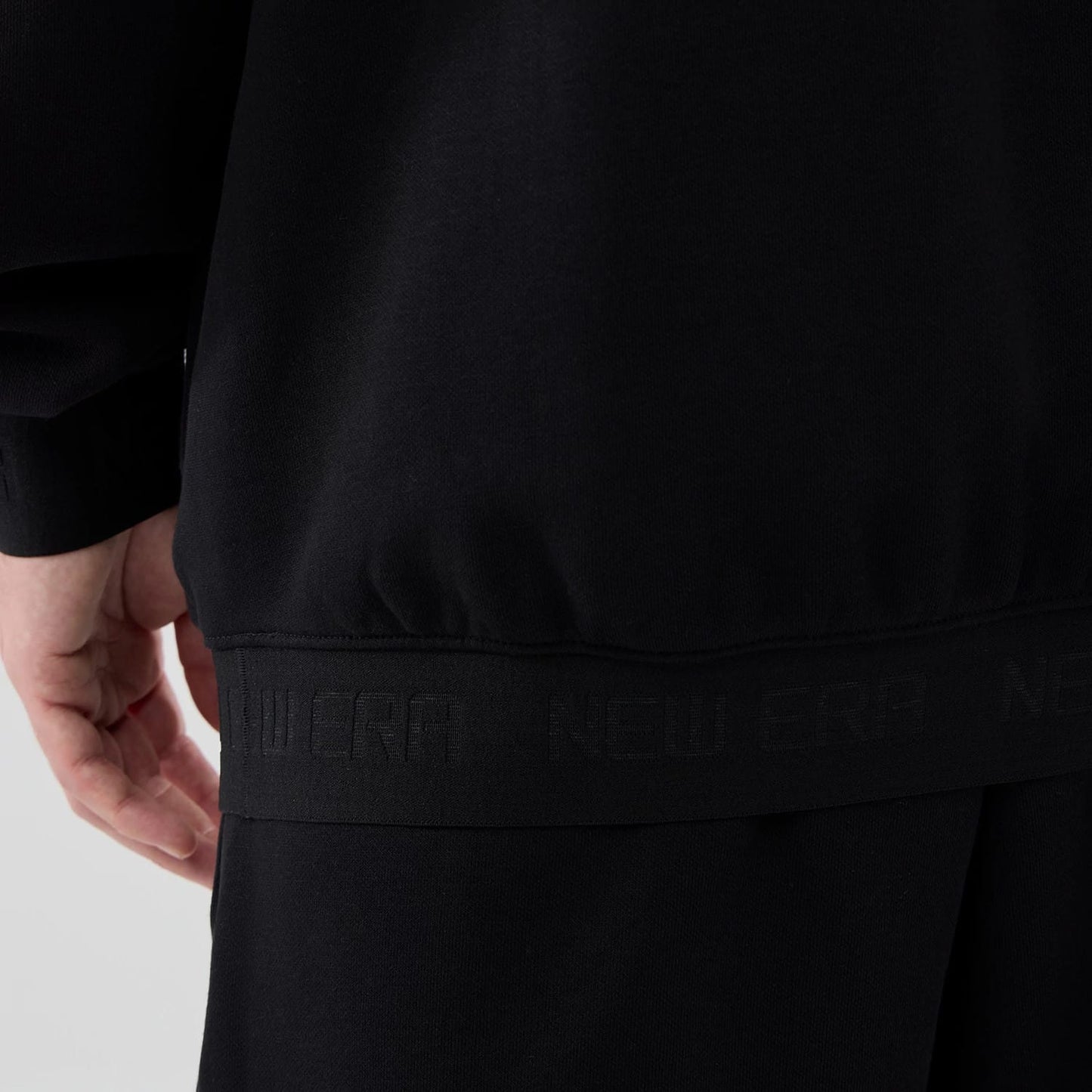 The model is wearing this New Era Tech Oversized Pullover Hoodie in black. 7