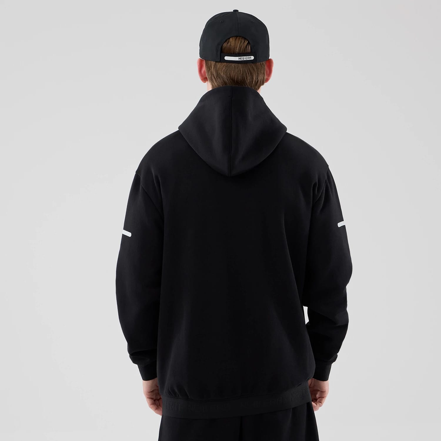 The model is wearing this New Era Tech Oversized Pullover Hoodie in black. 2