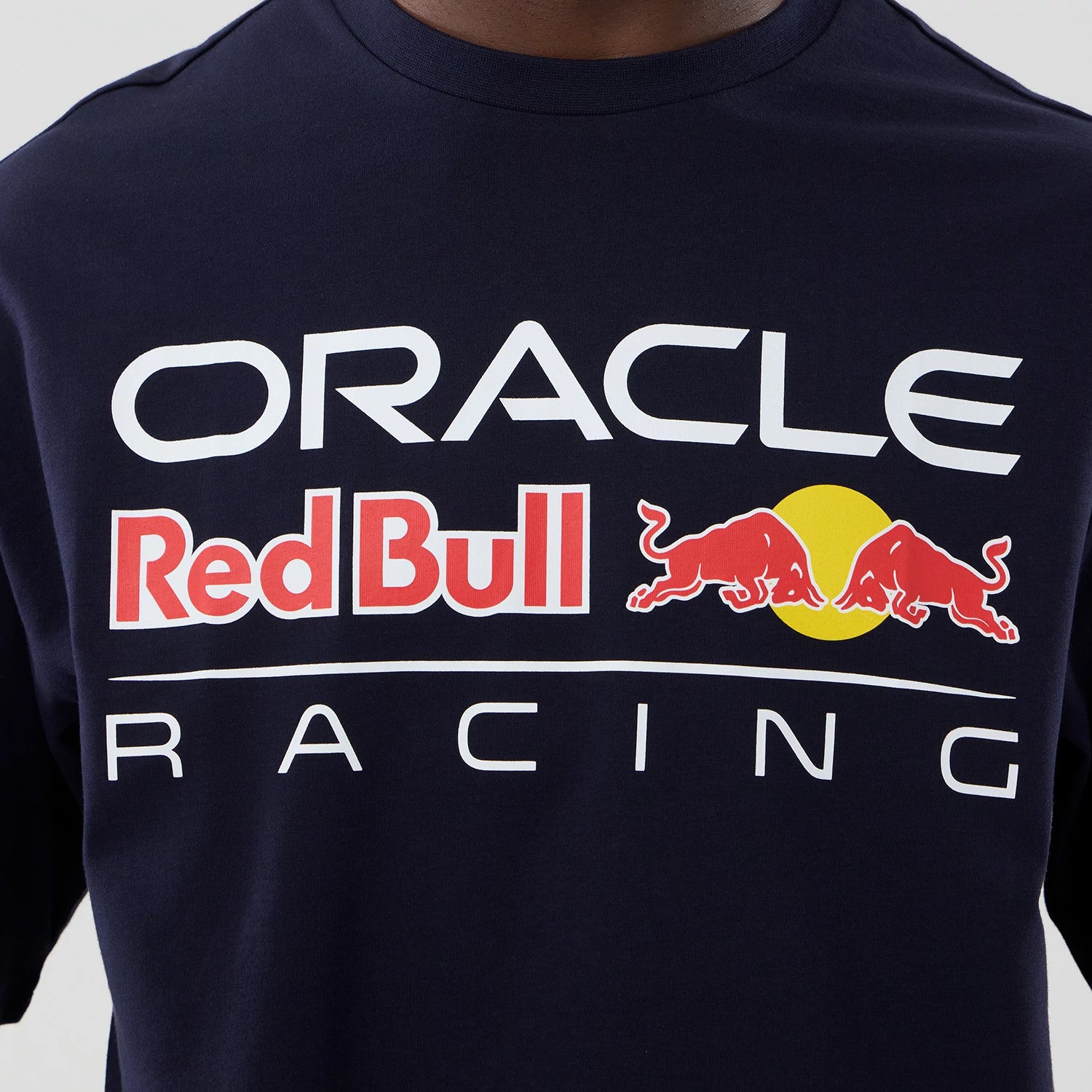 New Era Red Bull Racing Graphic Dark Blue Oversized T-Shirt, front view showing the printed Oracle Red Bull Racing logo across the chest in white and red, featuring the red bulls and yellow circle emblem centred prominently below the collar.