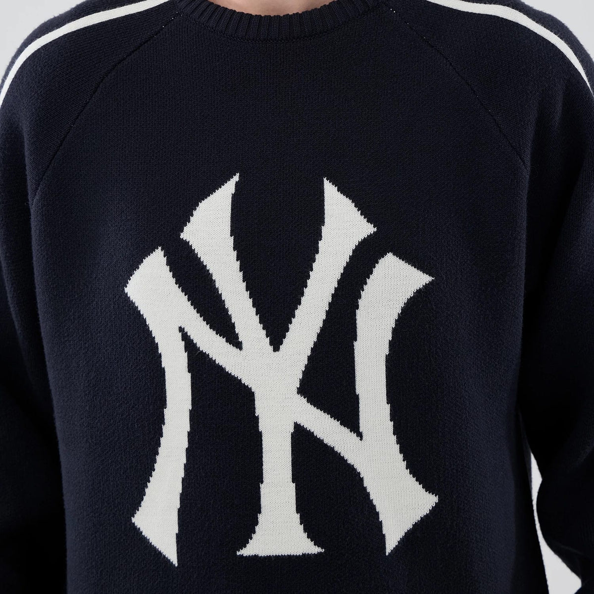 New Era New York Yankees MLB Knit Navy Knitted Sweater, front view showing a large white knitted NY logo on the chest, with ribbed crew neck and white shoulder stripes on the navy background.