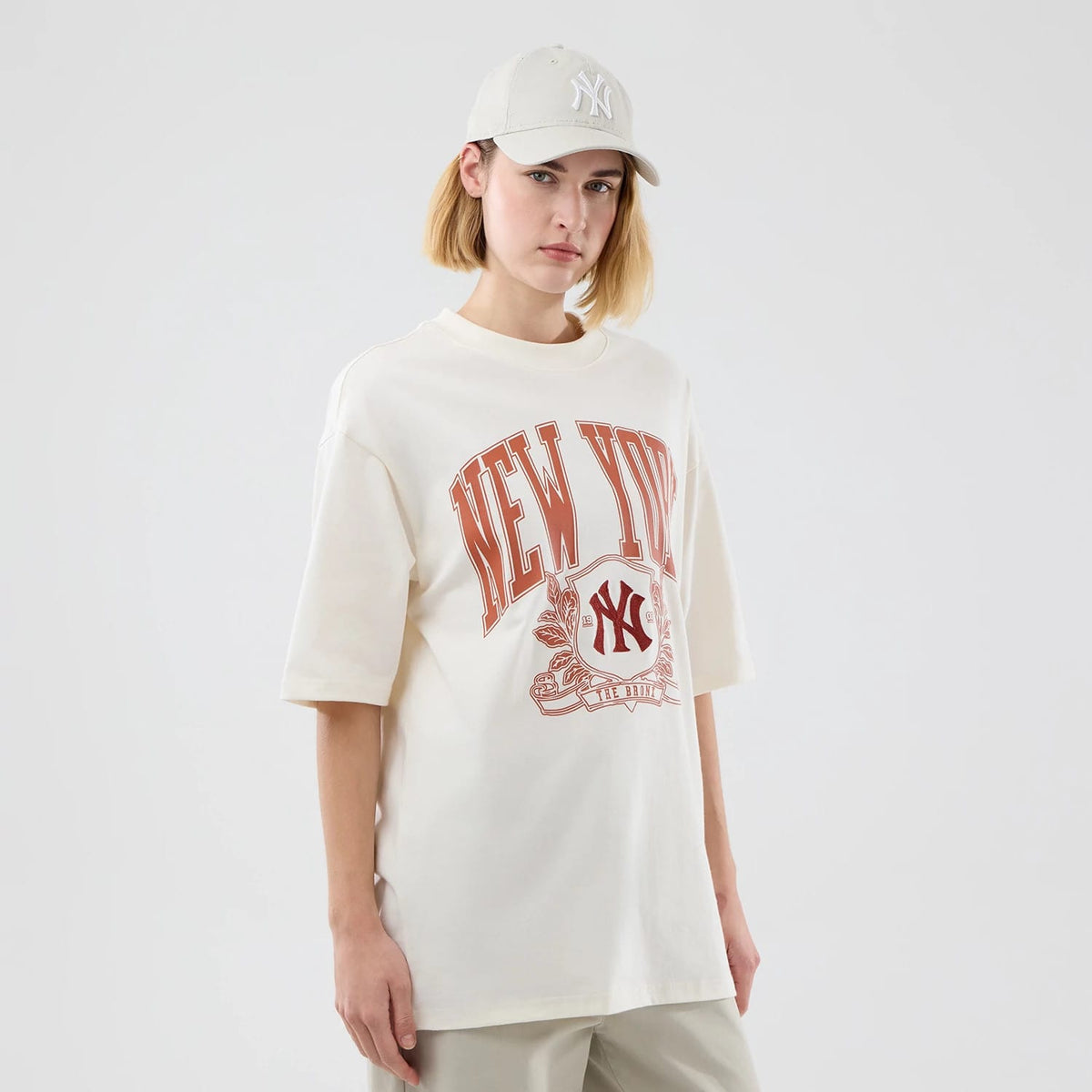 New Era New York Yankees MLB Arch Graphic Open White Oversized T-Shirt, front view on a model, showing red New York graphics with an intricate design and NY logo across the chest, complementing the white oversized fit with short sleeves.