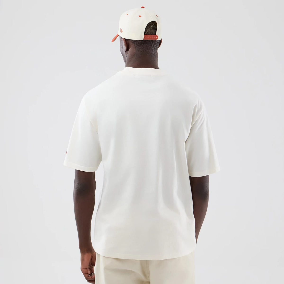 New Era New York Yankees MLB Arch Graphic Open White Oversized T-Shirt, back view on a model styled with a matching cap, showing the plain white oversized back, short sleeves and a small embroidered logo on the left sleeve.