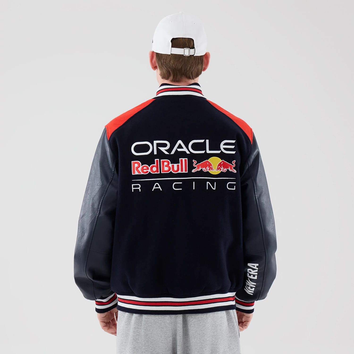 The model is wearing this Red Bull Racing wordmark Varsity Jacket in dark blue. 2