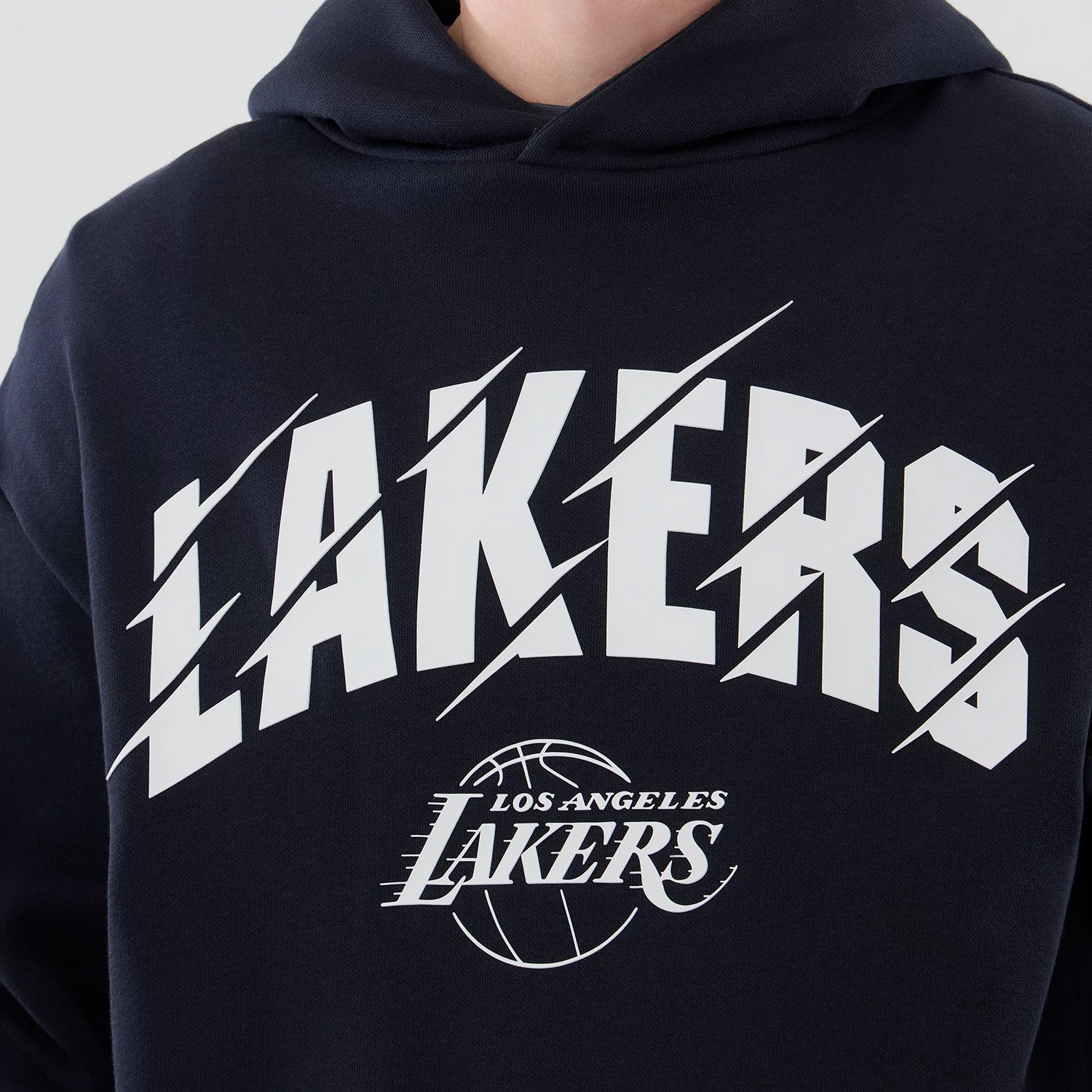 New Era LA Lakers NBA Core Plus Navy Pullover Hoodie, front view showcasing the white LAKERS lettering with diagonal slashes across the chest, and the detailed LOS ANGELES LAKERS printed logo featuring a basketball design below the main text.