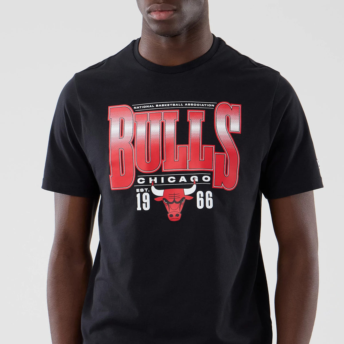New Era Chicago Bulls NBA Arch Graphic Black T-Shirt, front view showing a large red Bulls graphic with an embroidered bull's head logo below, complemented by Chicago lettering and Established 1966 details in white across the chest.