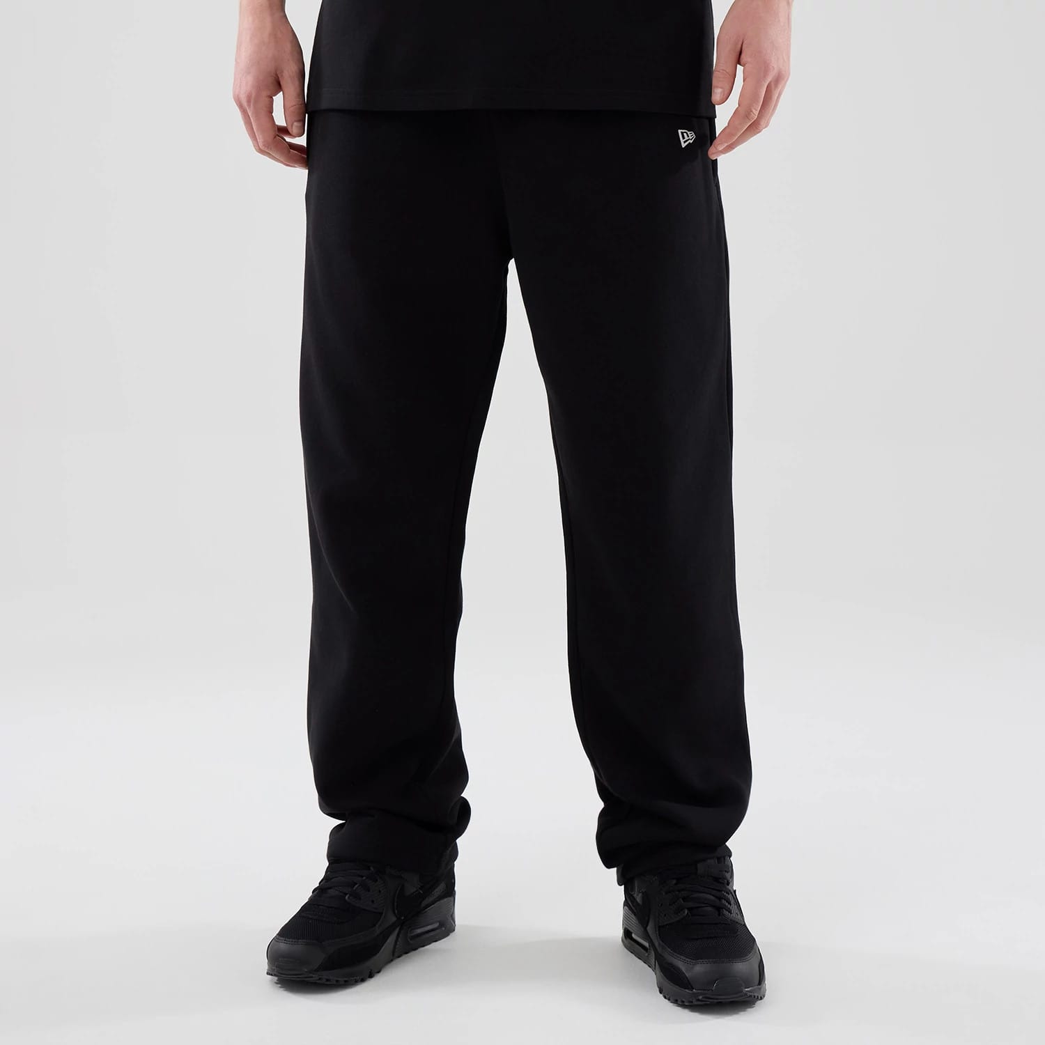 The model is wearing these New Era Tech Reflective Straight Leg Joggers in black. 1