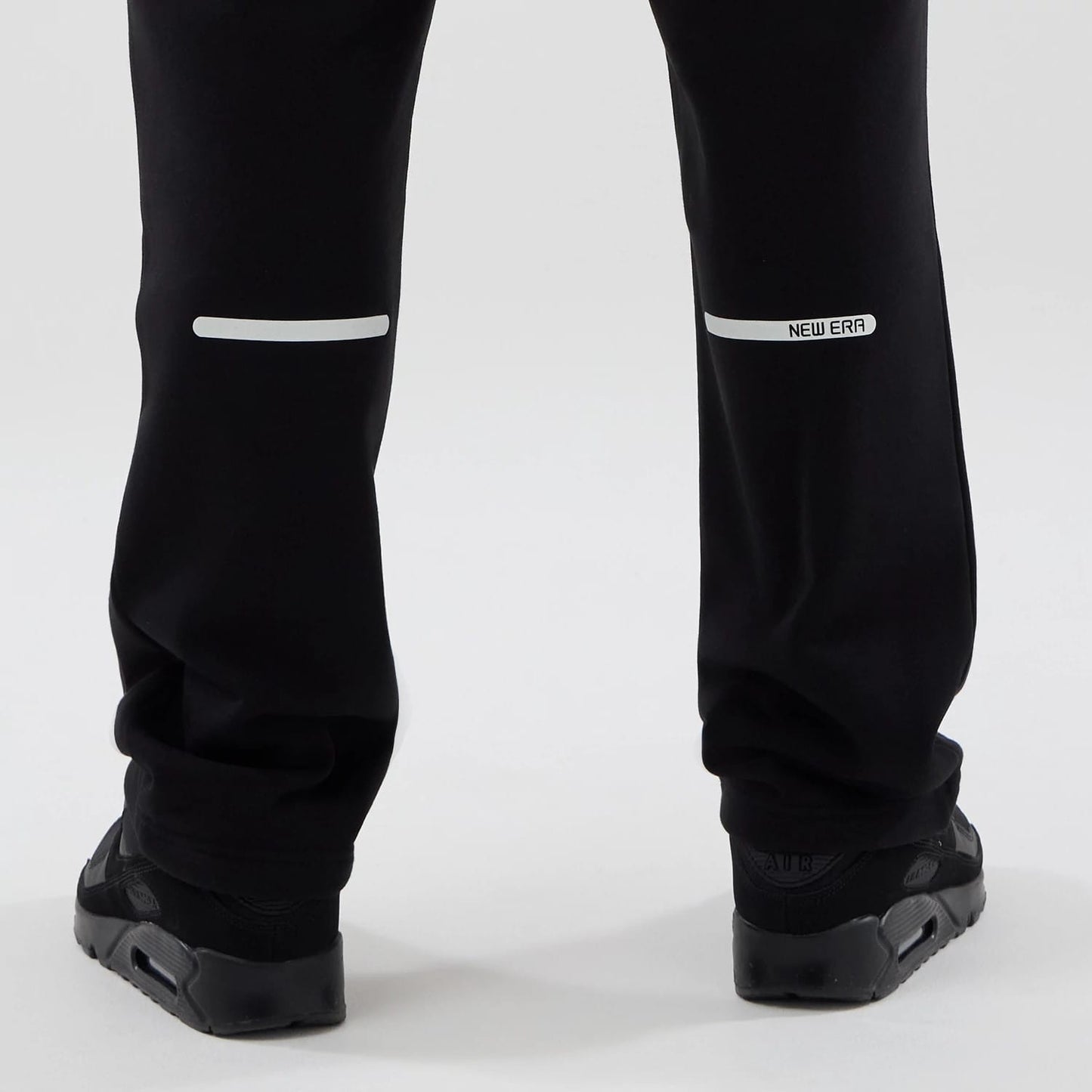 The model is wearing these New Era Tech Reflective Straight Leg Joggers in black. 7