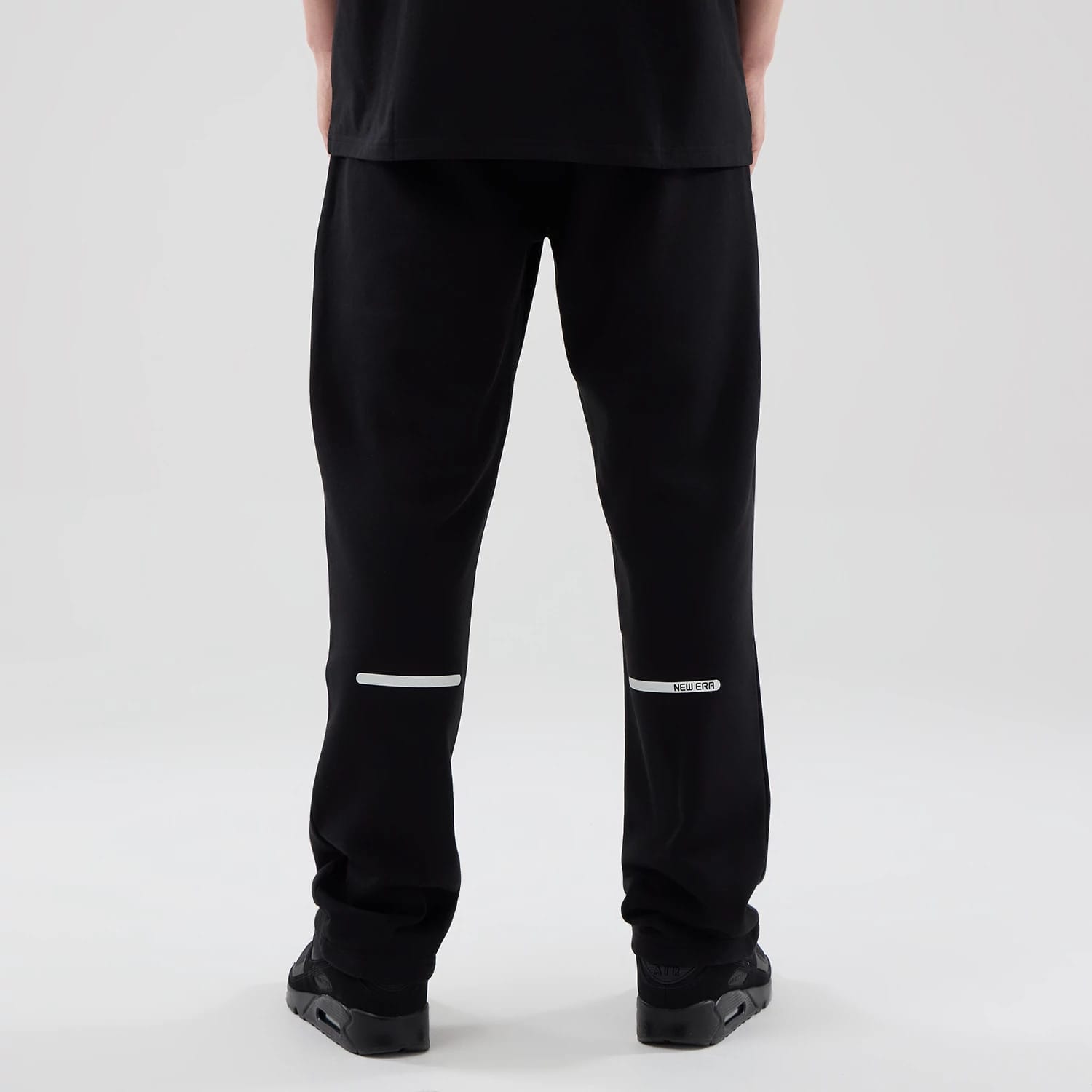 The model is wearing these New Era Tech Reflective Straight Leg Joggers in black. 2