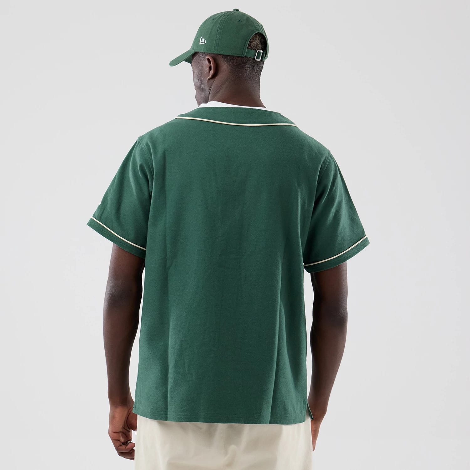 The model is wearing this New Era Baseball Jersey in dark green. 2