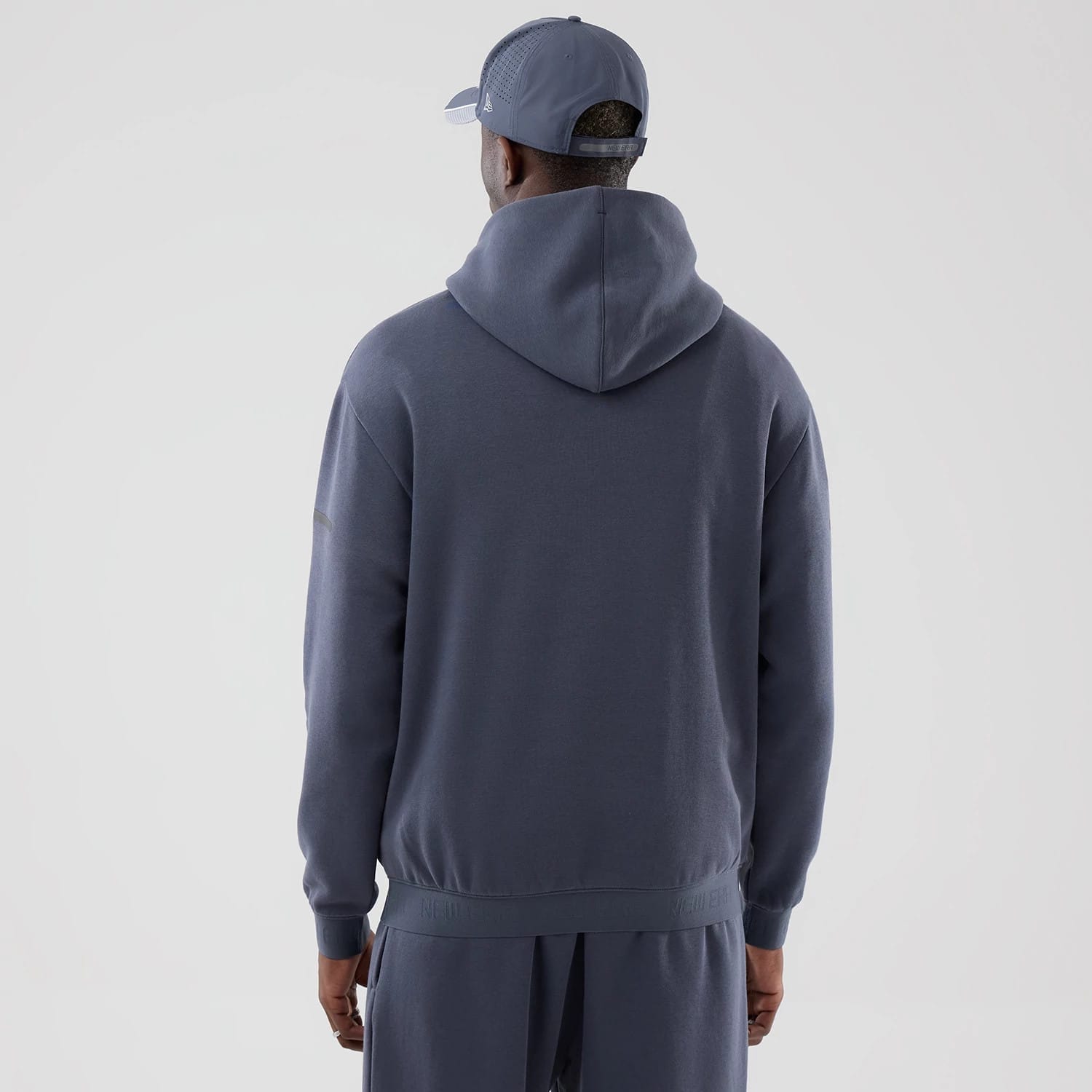 The model is wearing this New Era Tech Oversized Pullover Hoodie in grey. 2