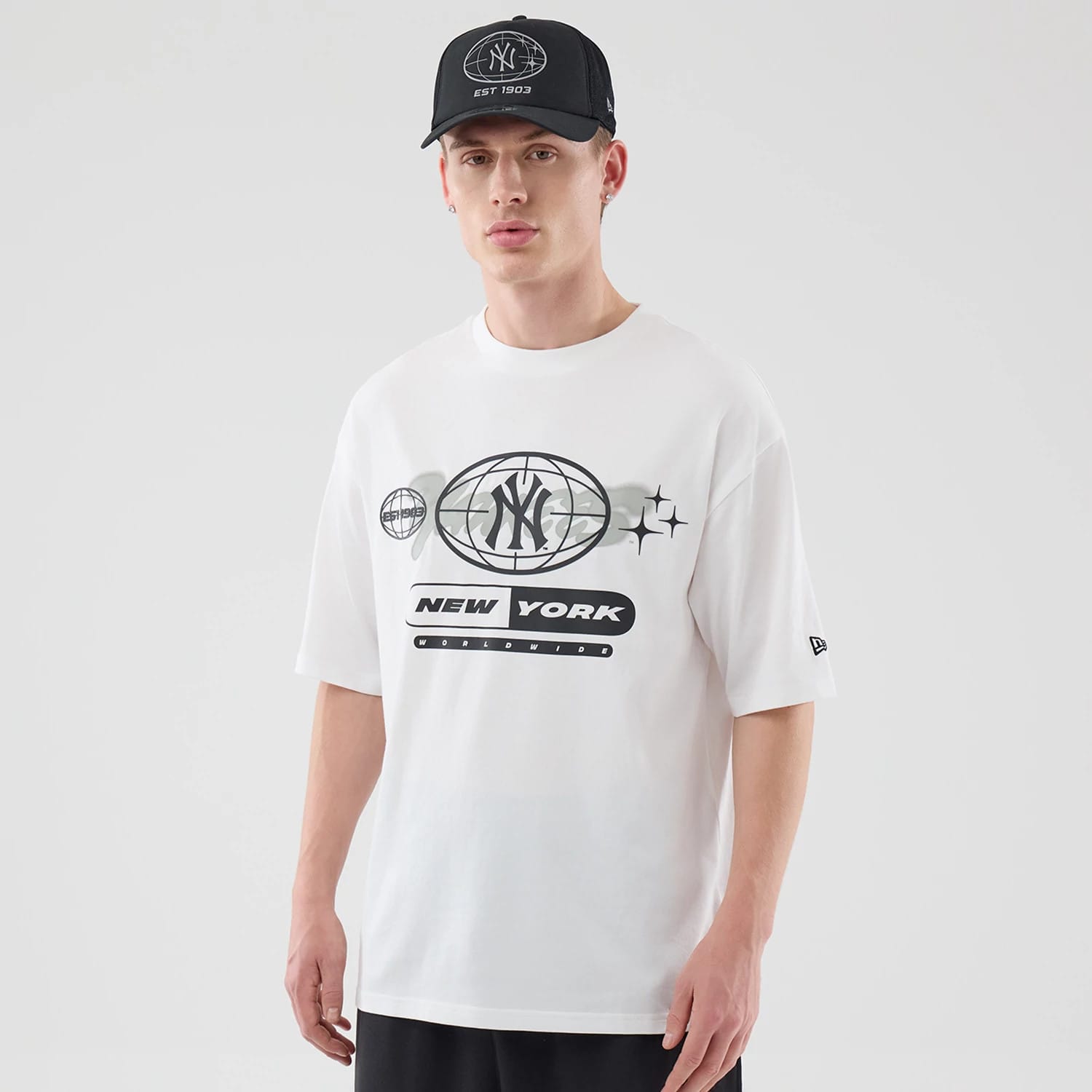 The model is wearing this MLB Logo Graphic New York Yankees Oversized T-Shirt in white. 1