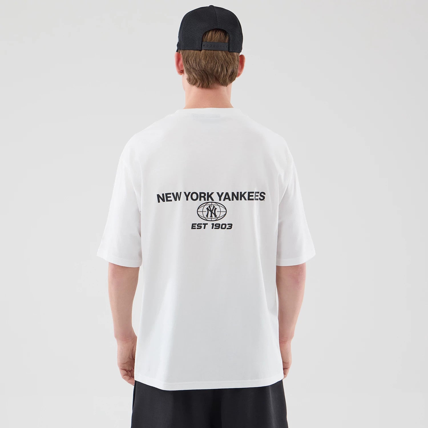 The model is wearing this MLB Logo Graphic New York Yankees Oversized T-Shirt in white. 2