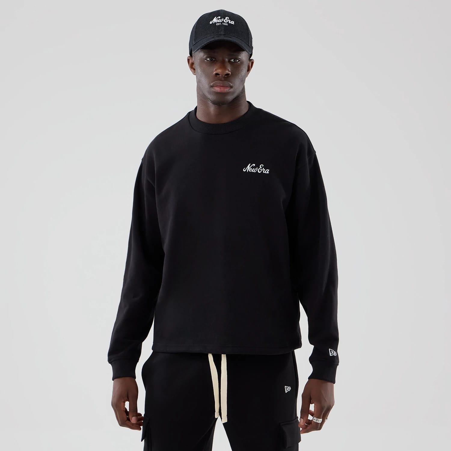 The model is wearing this New Era Oversized Crew Neck Sweater in black. 1