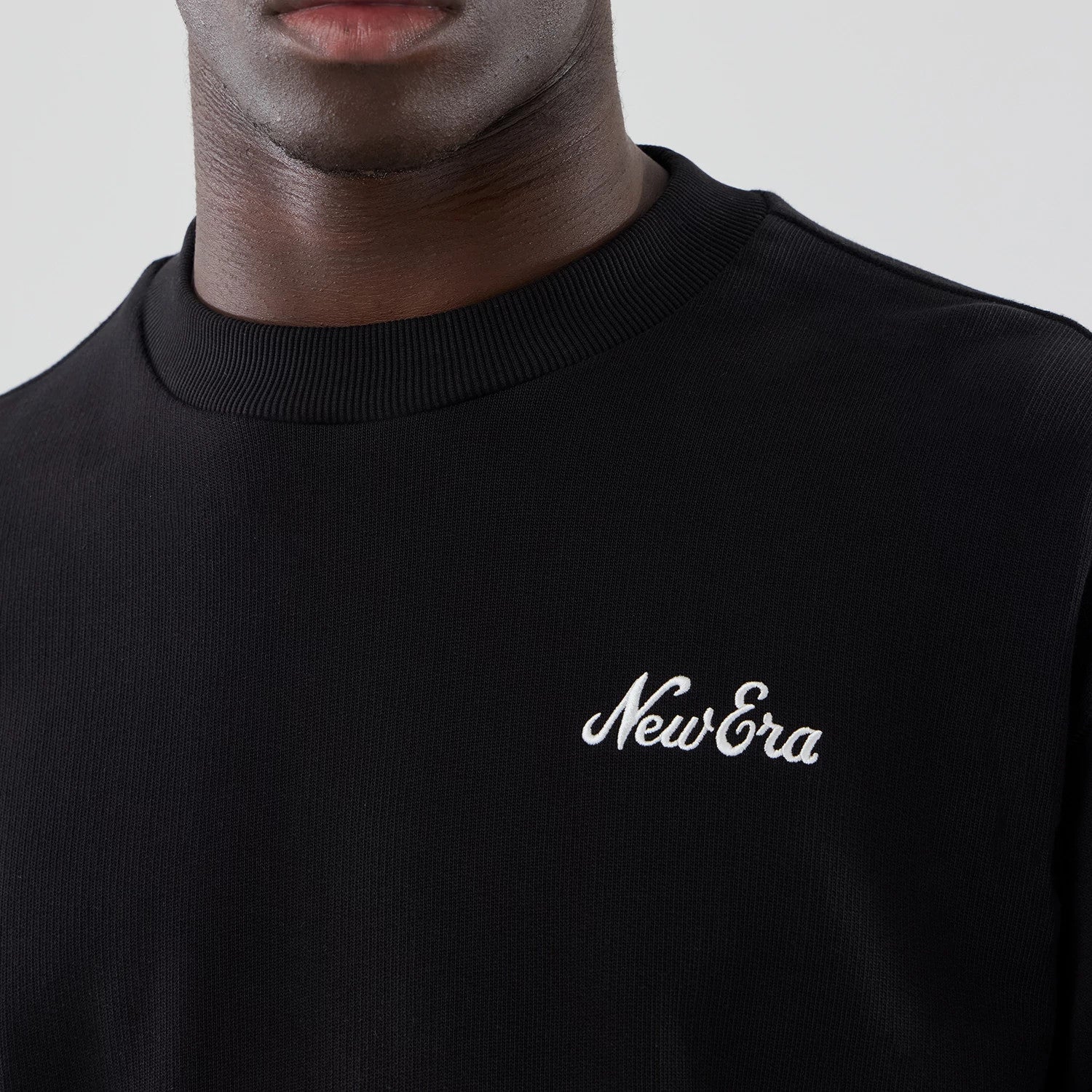 The model is wearing this New Era Oversized Crew Neck Sweater in black. 4