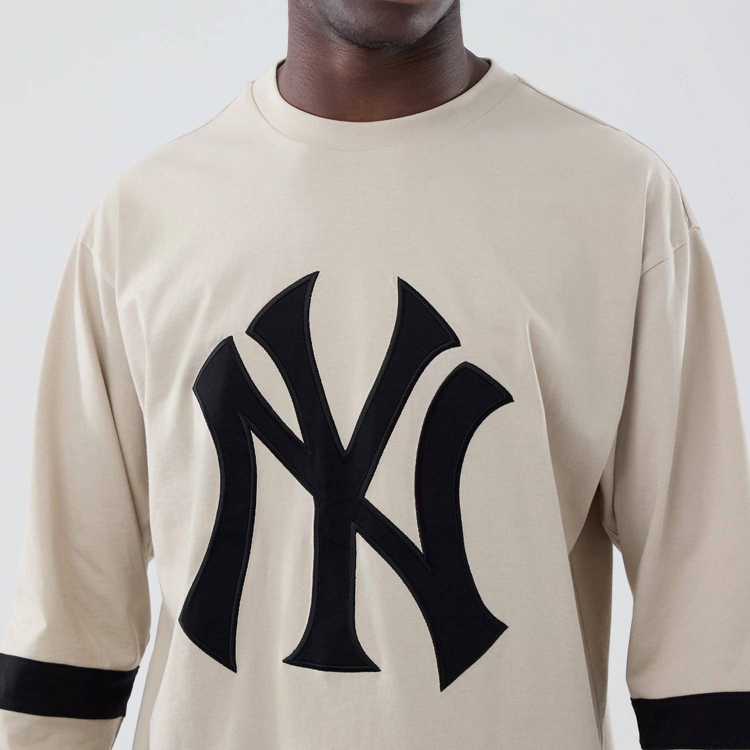 The model is wearing this MLB New York Yankees Oversized Long Sleeve T-Shirt in light beige. 4