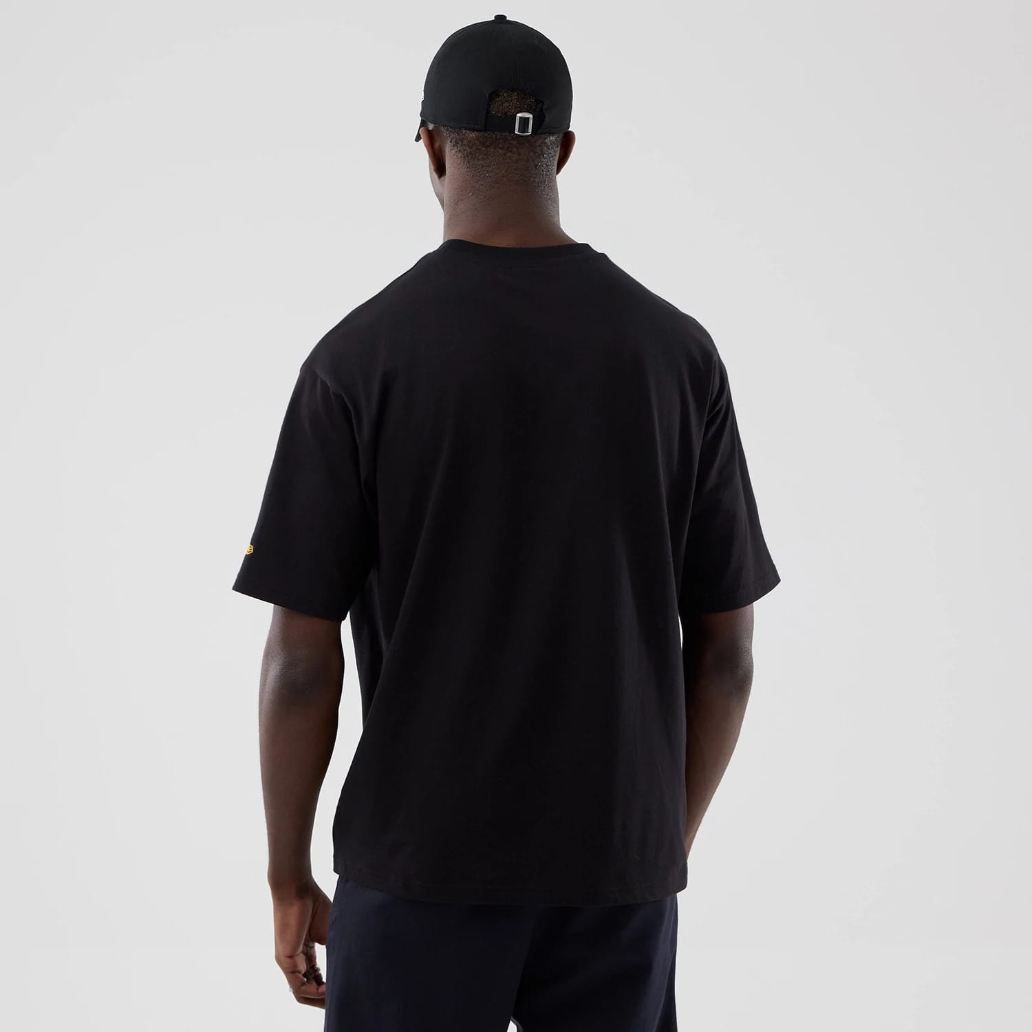 The model is wearing this New Era Motor Graphic Oversized T-Shirt in black. 2