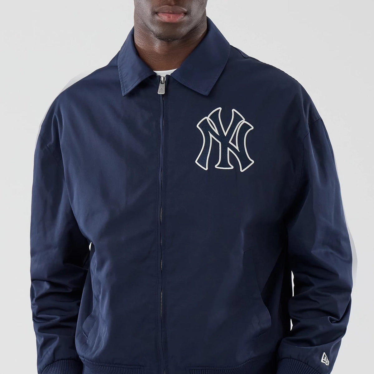 New Era New York Yankees MLB Collared Navy Jacket, front view showing a prominent white embroidered Yankees logo on the left chest, a full zip closure extending up to the collar, and a small embroidered New Era logo near the left cuff.