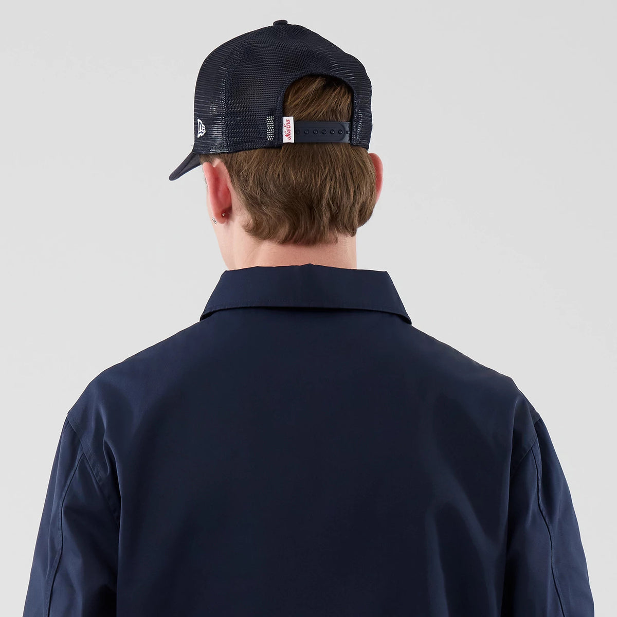 New Era Navy Shacket, back view on a model showing the structured navy collar, fabric with a clean finish, and the complementary dark blue cap featuring a mesh rear panel and adjustable strap.