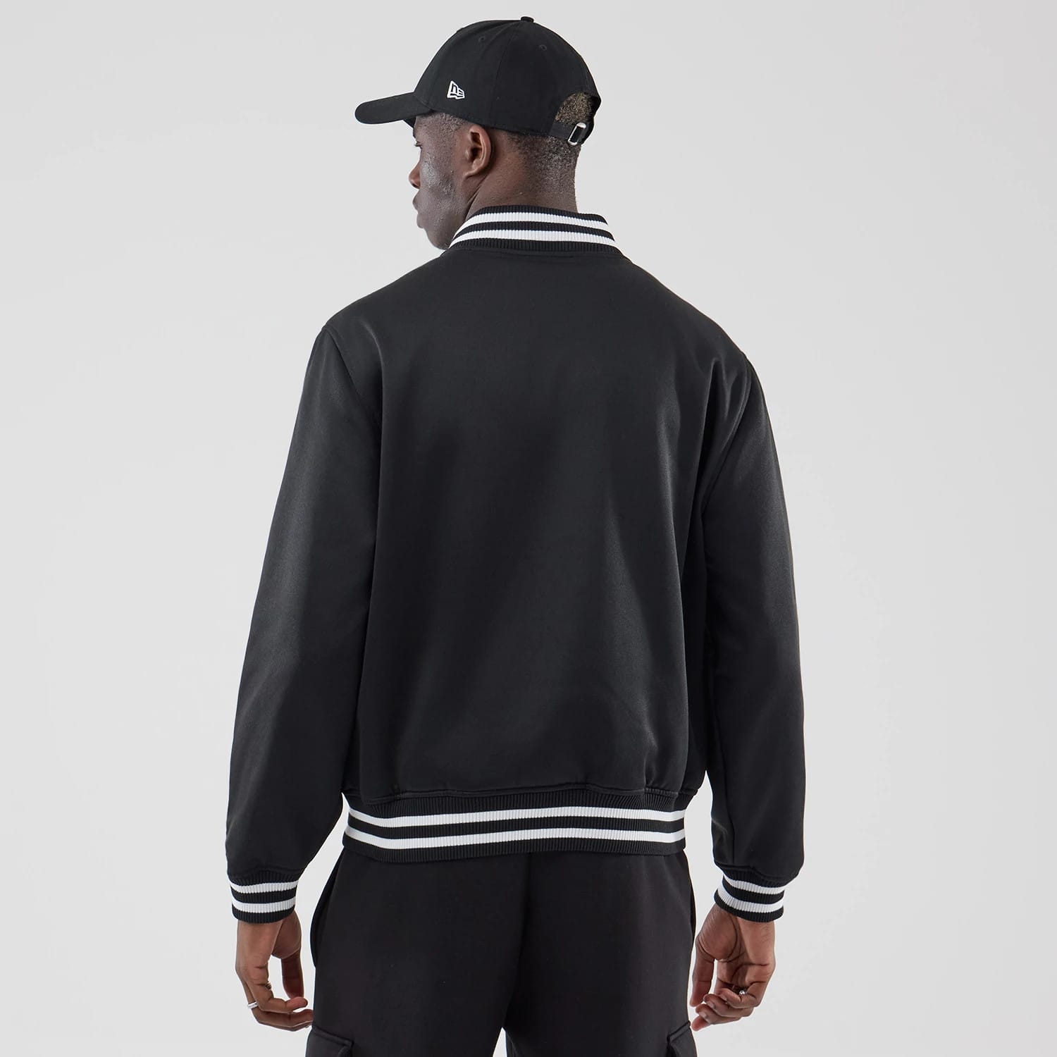 The model is wearing this New Era Jersey Bomber Jacket in black. 2