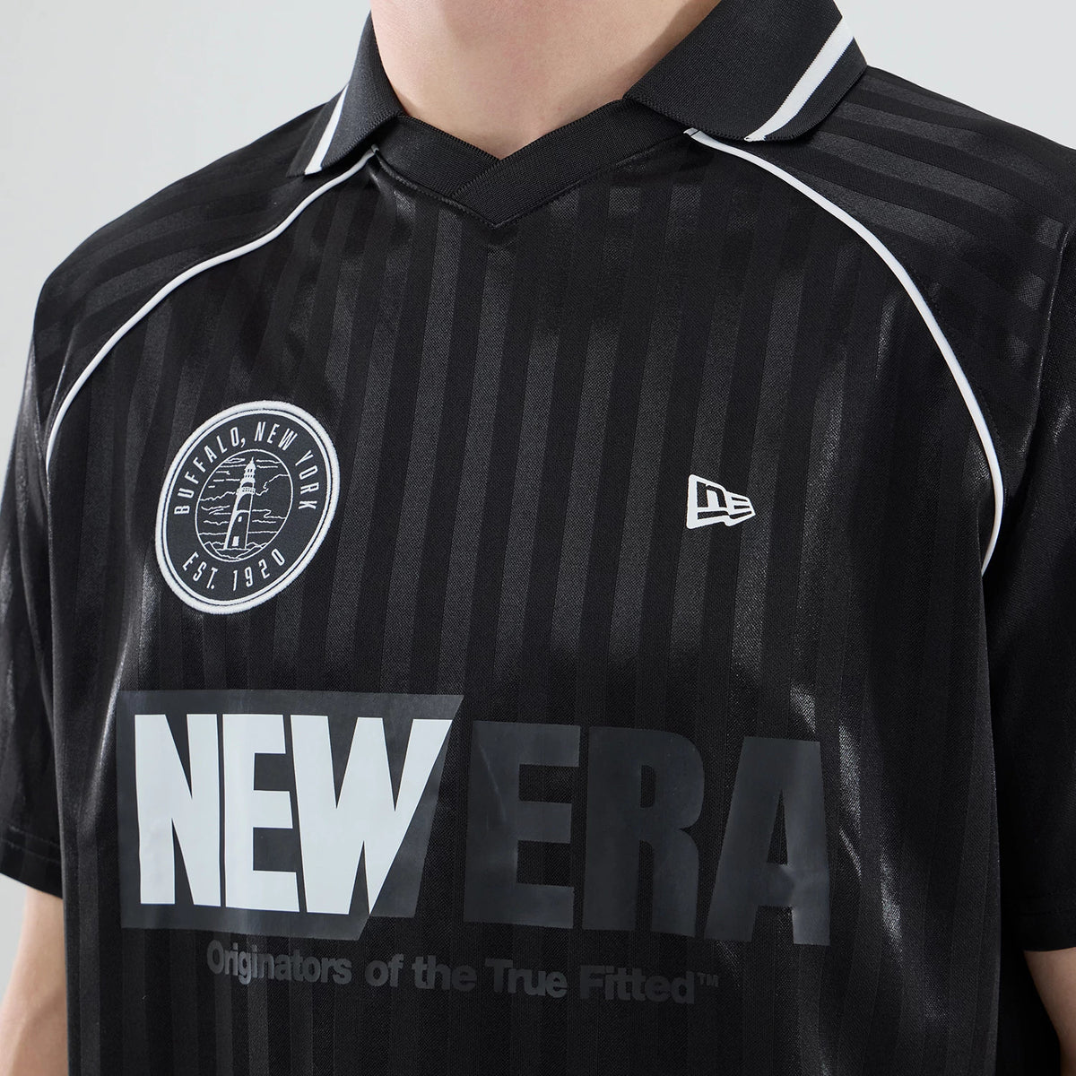 New Era Black Football Jersey T-Shirt, front view showing vertical stripes on a black background, a printed New Era logo on the left chest, a large NEWERA print across the front, and a round Buffalo New York emblem near the shoulder.