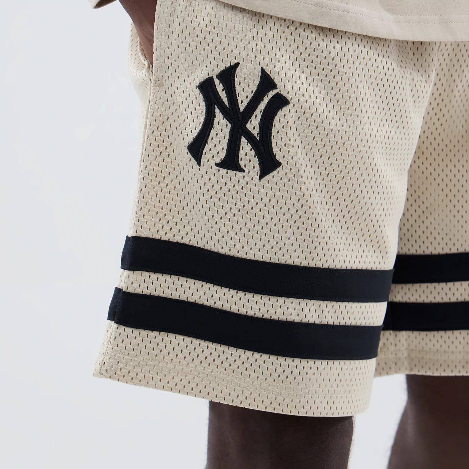 The model is wearing these MLB New York Yankees Oversized Mesh Shorts in light beige. 3