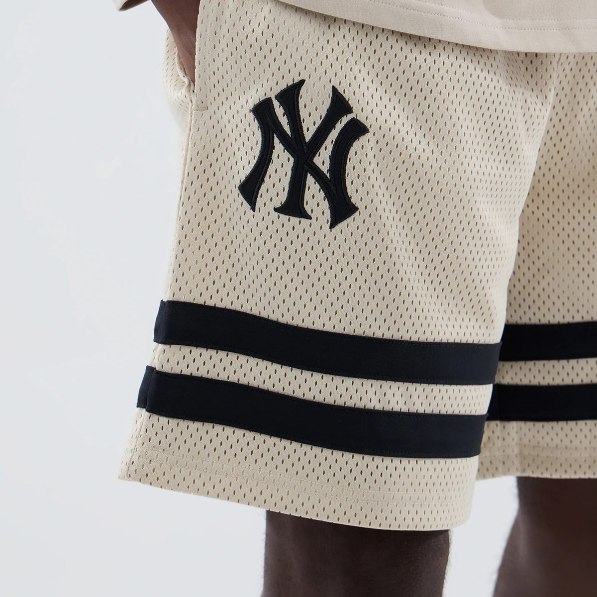 The model is wearing these MLB New York Yankees Oversized Mesh Shorts in light beige. 3