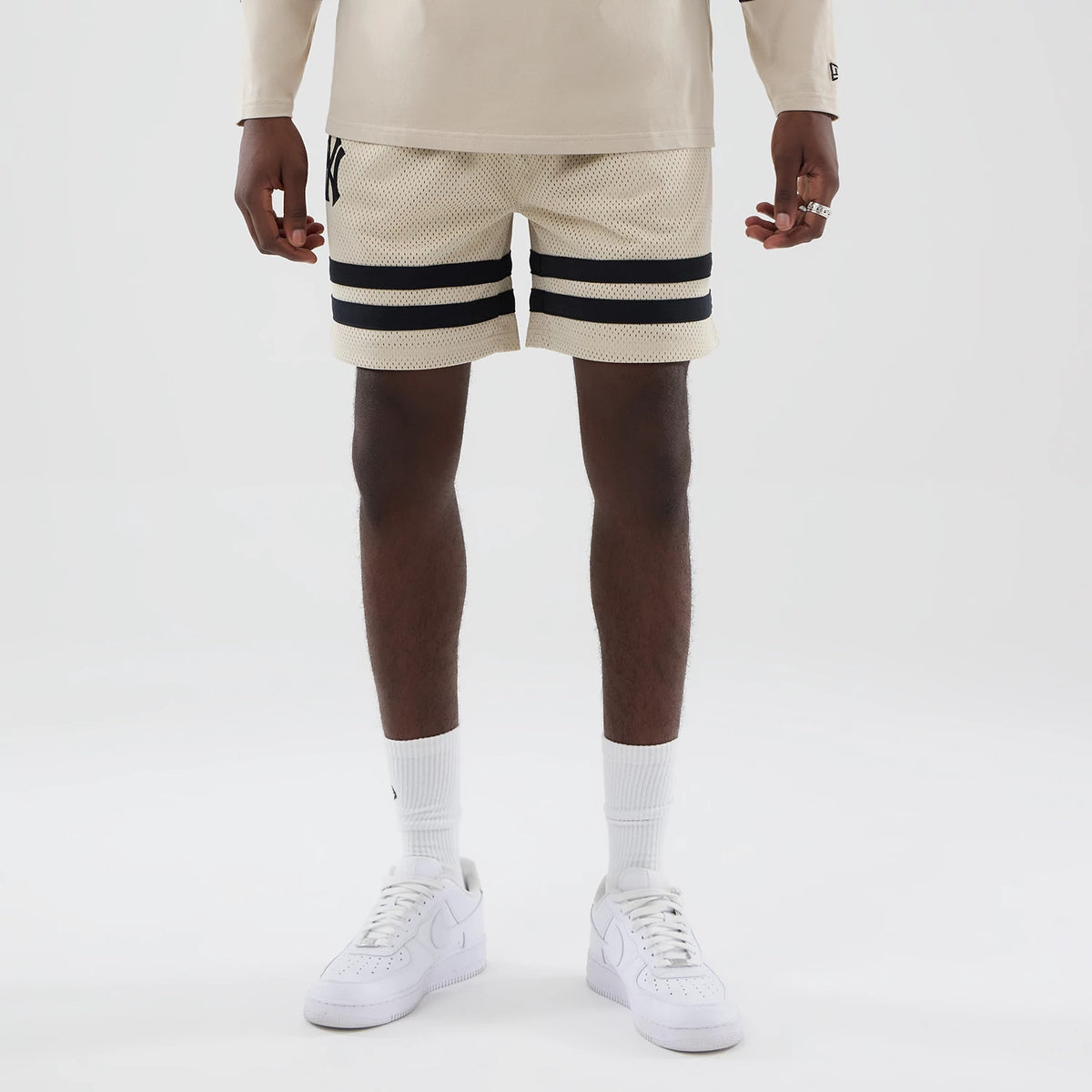 The model is wearing these MLB New York Yankees Oversized Mesh Shorts in light beige. 1