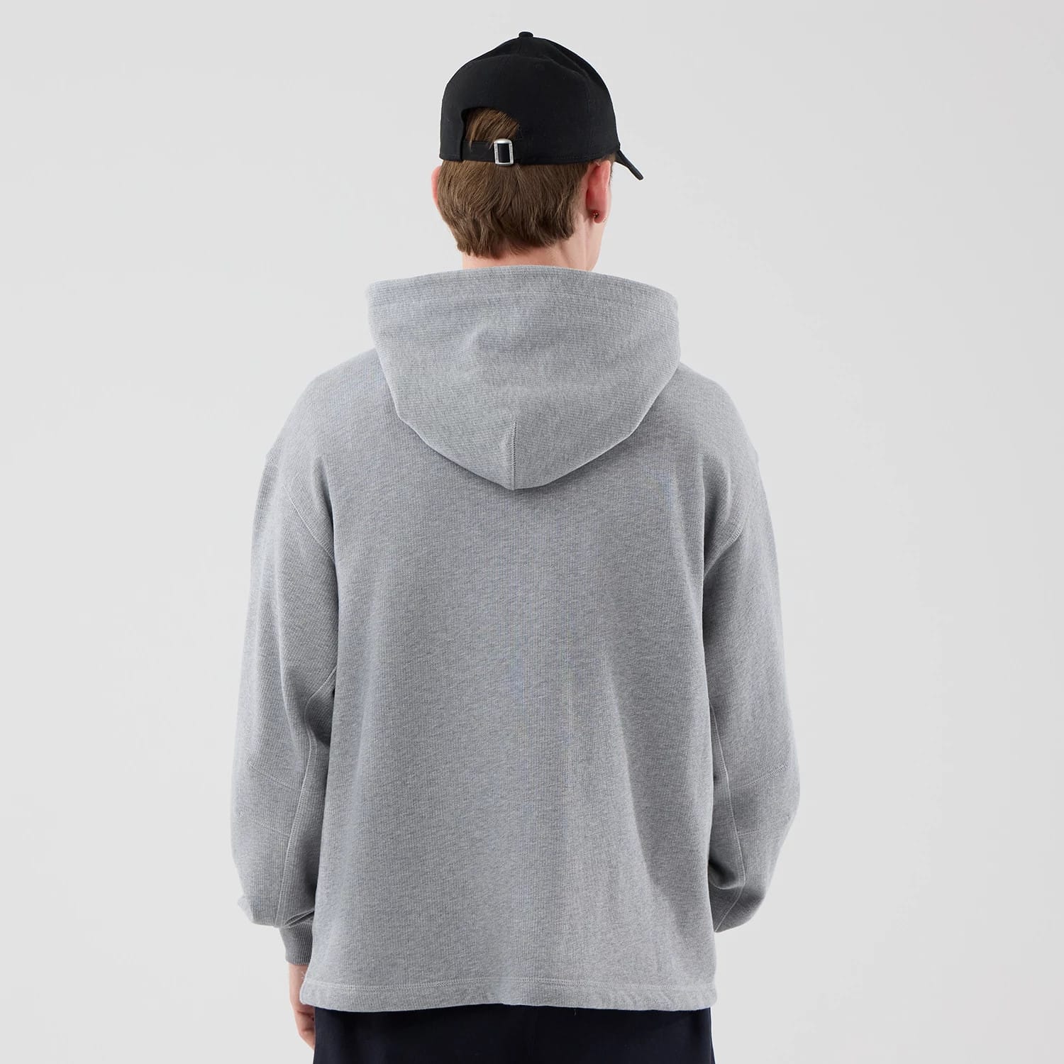The model is wearing this New Era Open Hem Pullover Hoodie in grey. 2