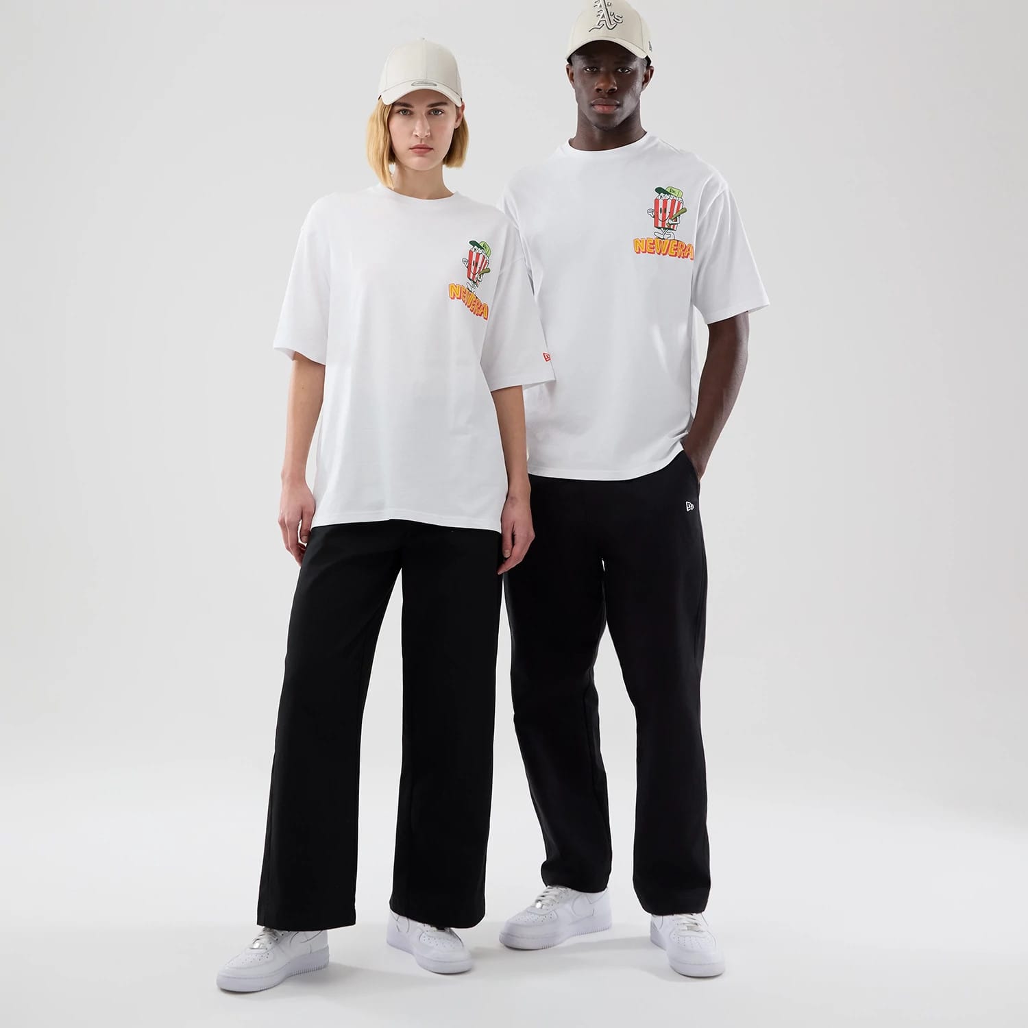 The model is wearing this New Era Baseball Popcorn Graphic Oversized T-Shirt in white. 1