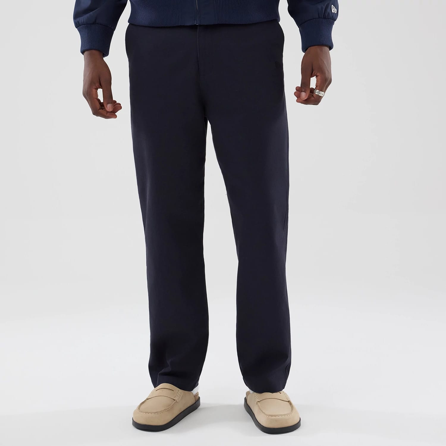 The model is wearing these New Era Chino Trousers in navy. 1