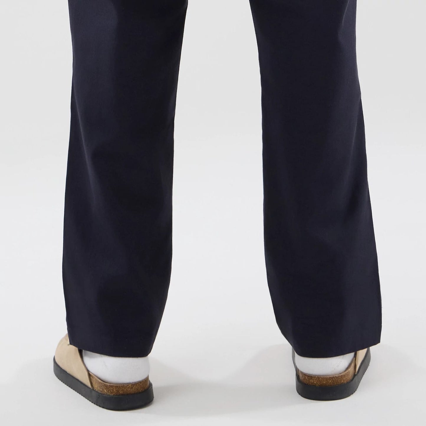 The model is wearing these New Era Chino Trousers in navy. 7