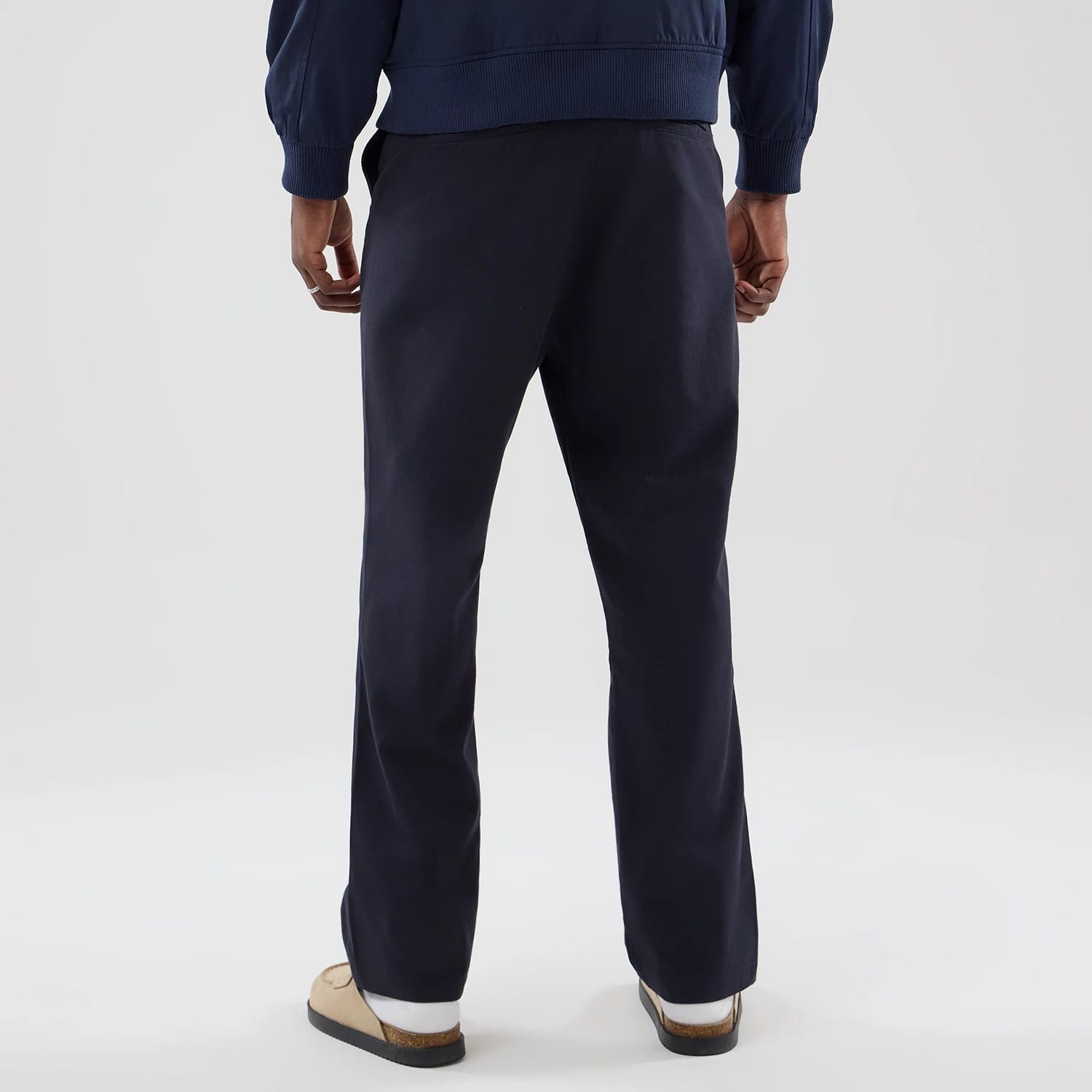 The model is wearing these New Era Chino Trousers in navy. 2