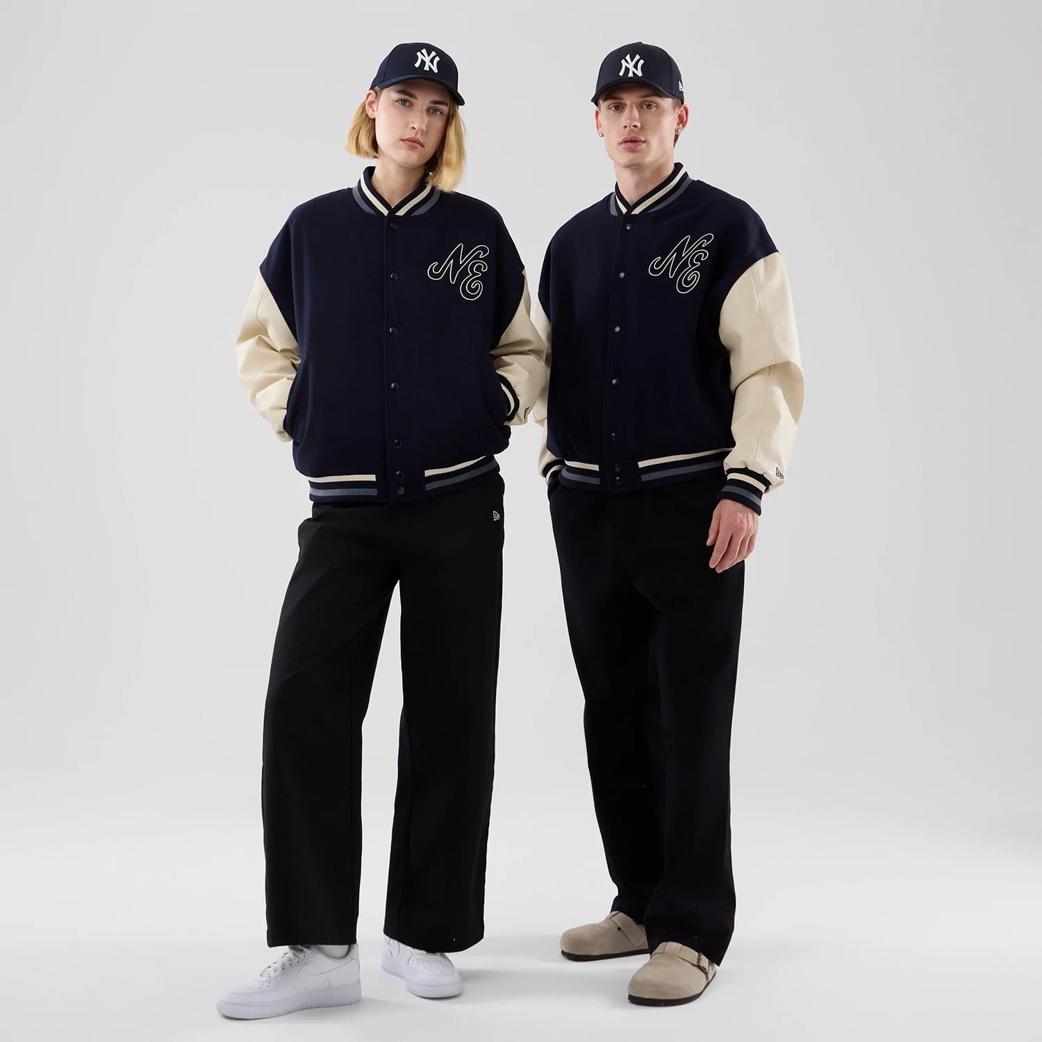The model is wearing this New Era Oversized Varsity Jacket in navy. 1