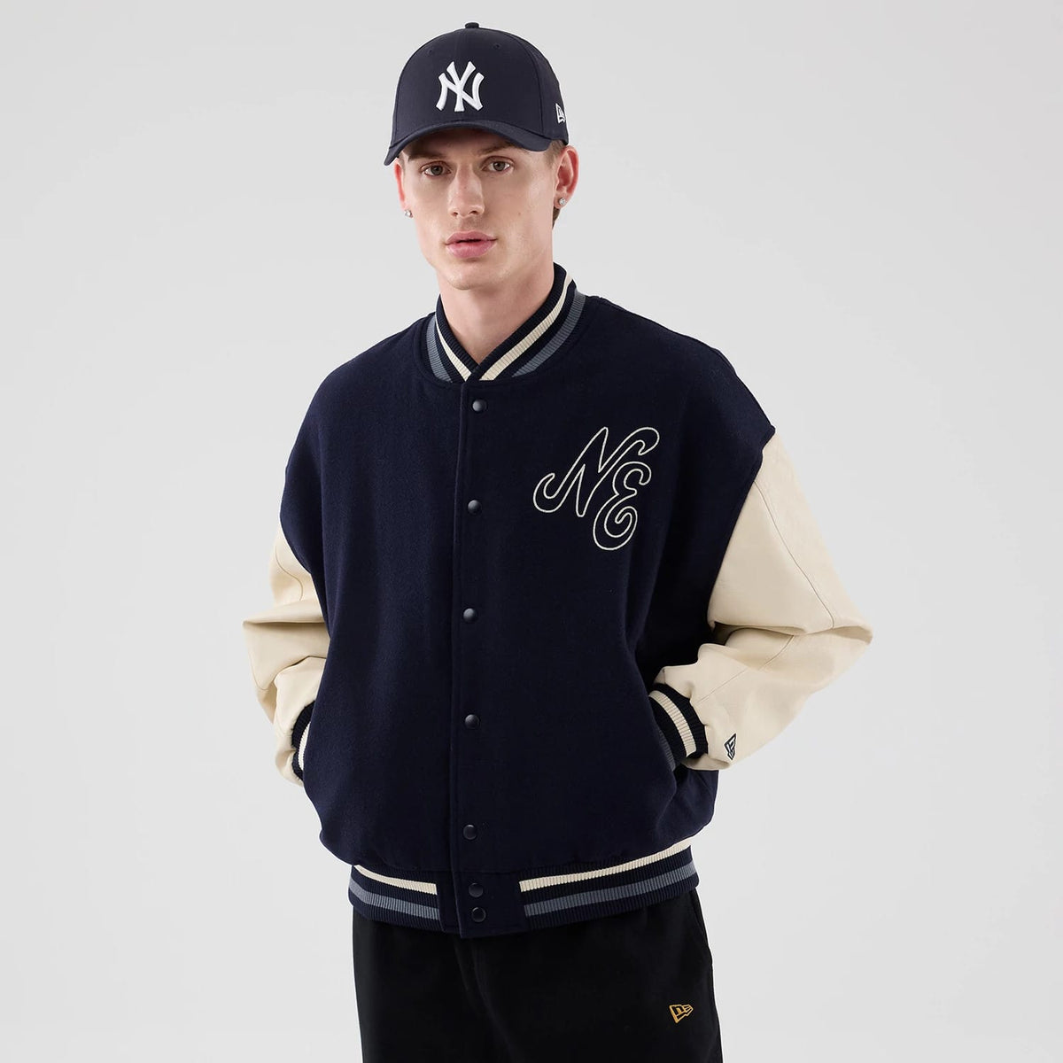 The model is wearing this New Era Oversized Varsity Jacket in navy. 3