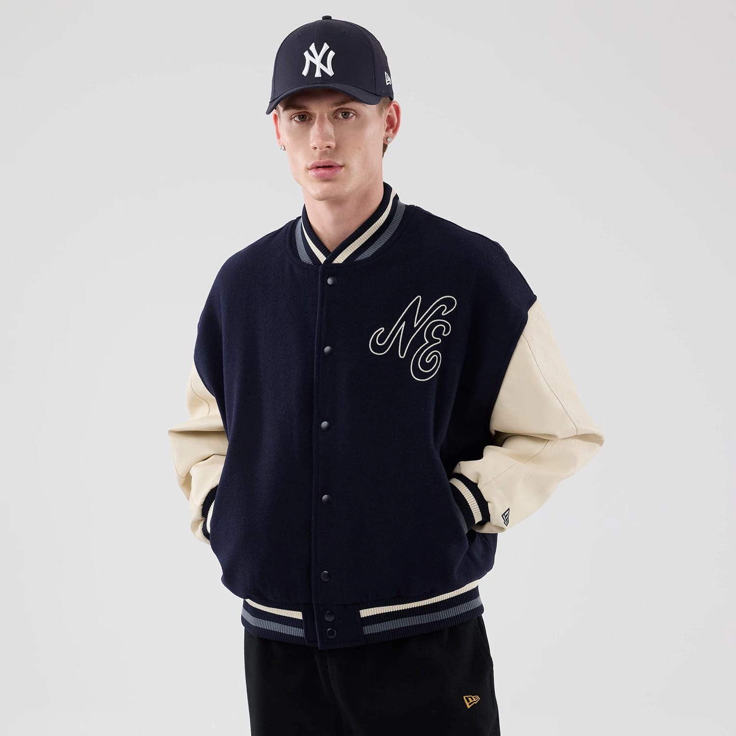 The model is wearing this New Era Oversized Varsity Jacket in navy. 3