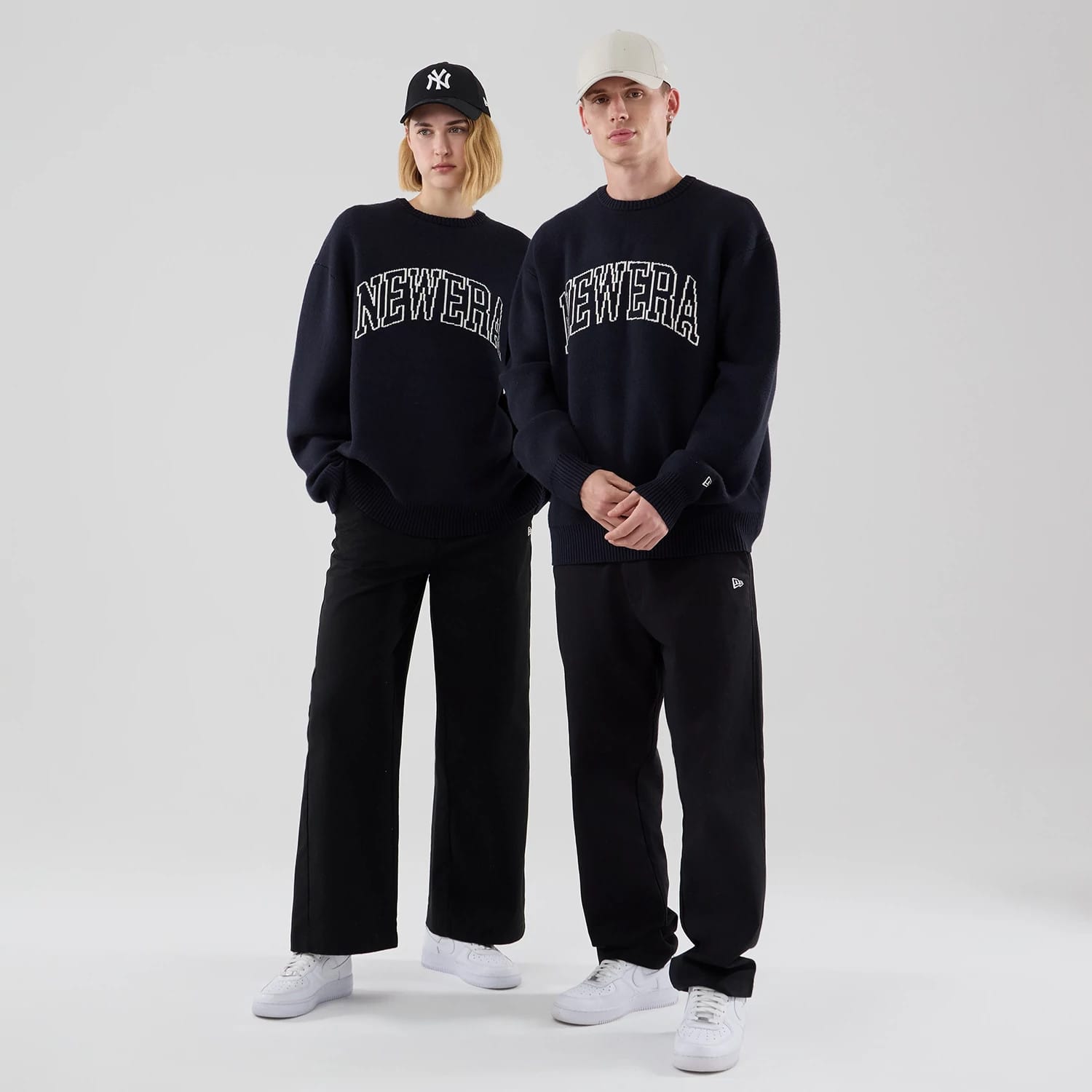 The model is wearing this New Era Knit Script Knitted Sweater in navy. 1