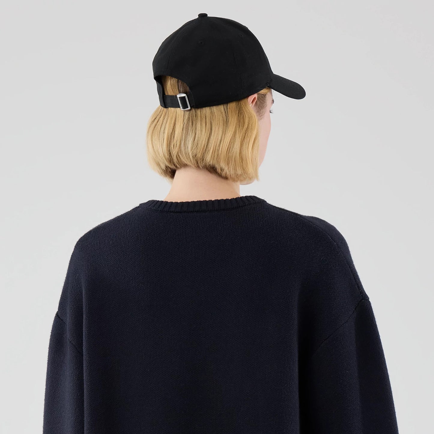 The model is wearing this New Era Knit Script Knitted Sweater in navy. 8
