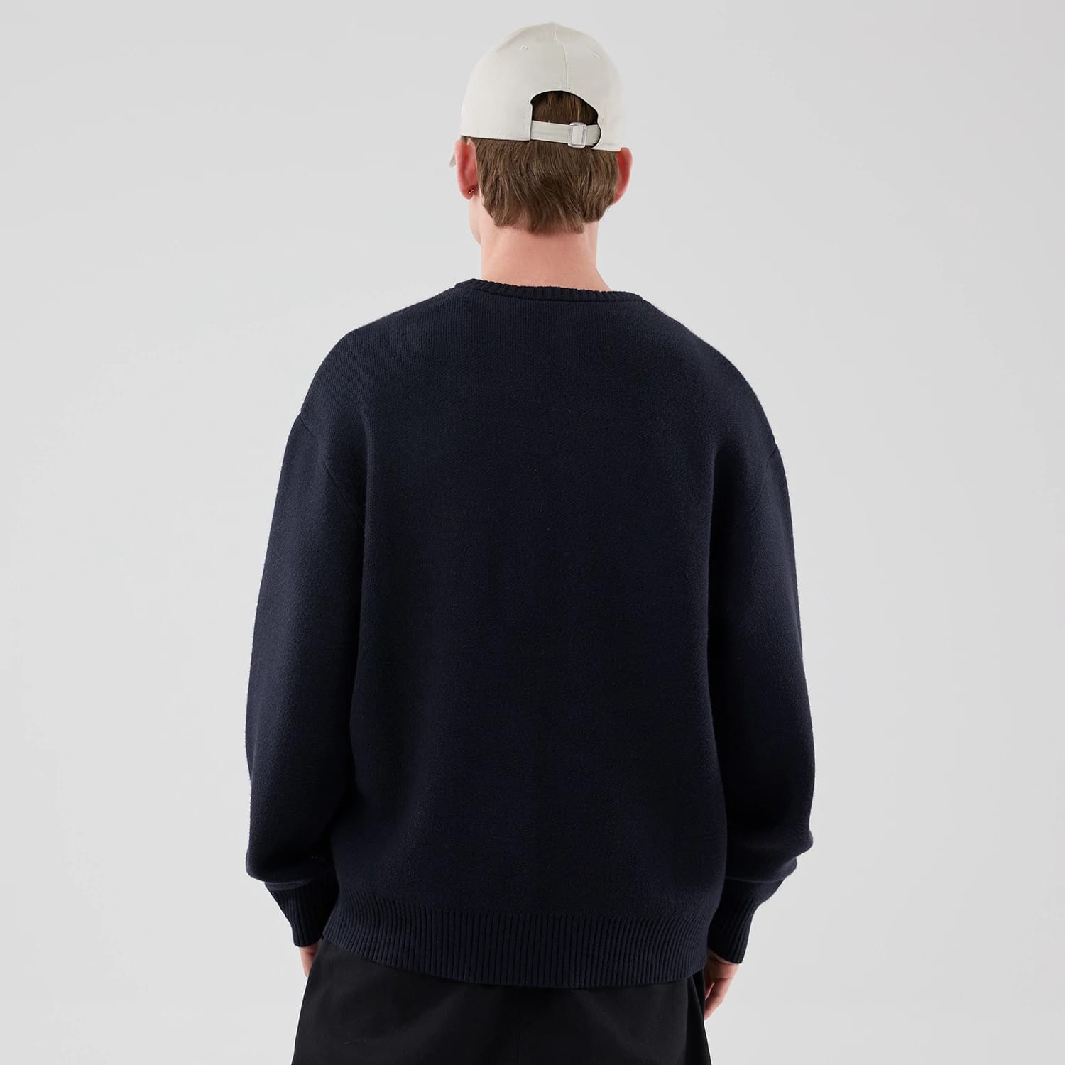 The model is wearing this New Era Knit Script Knitted Sweater in navy. 2