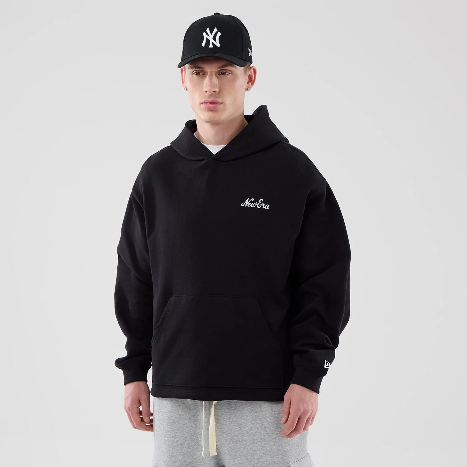The model is wearing this New Era Open Hem Pullover Hoodie in black. 1