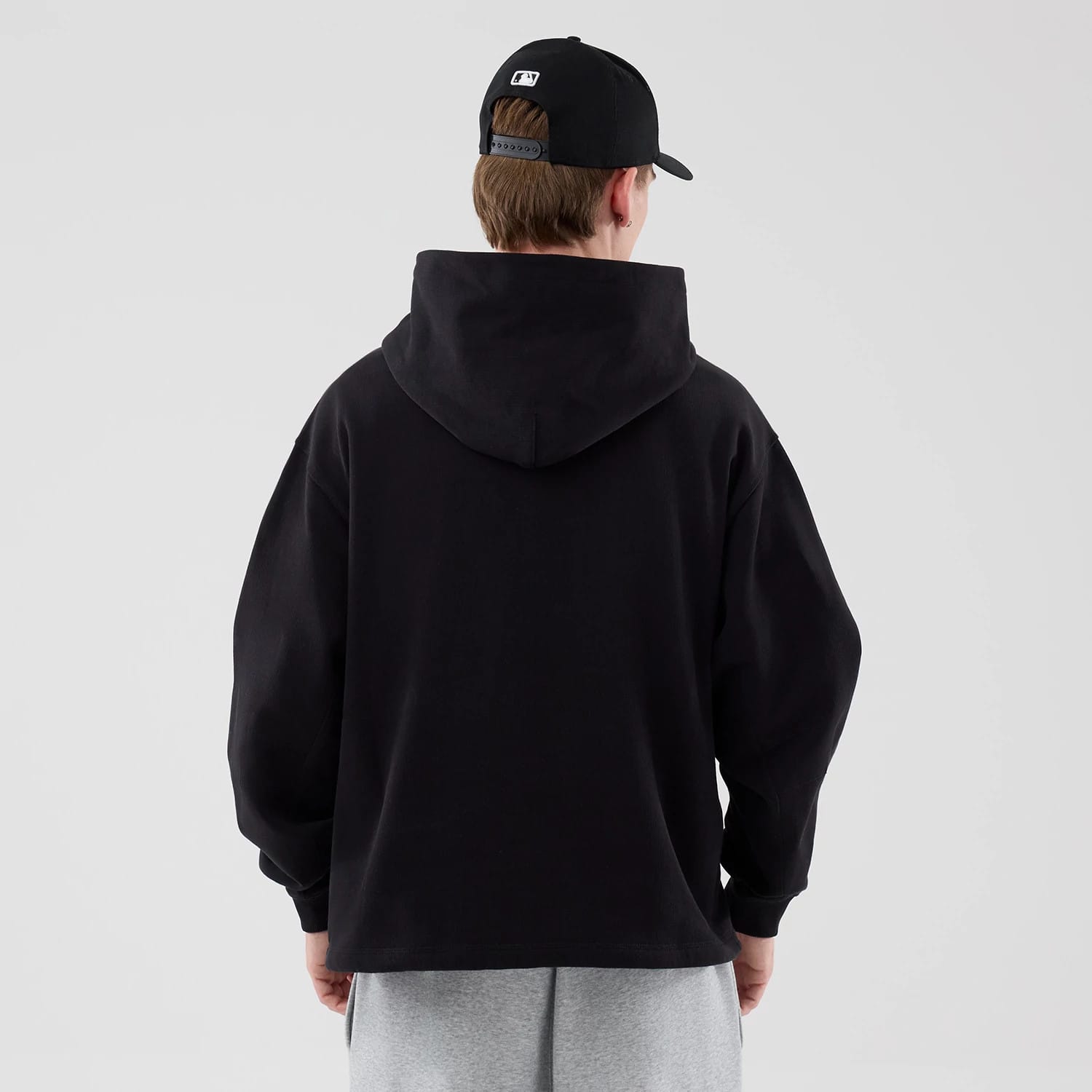 The model is wearing this New Era Open Hem Pullover Hoodie in black. 2