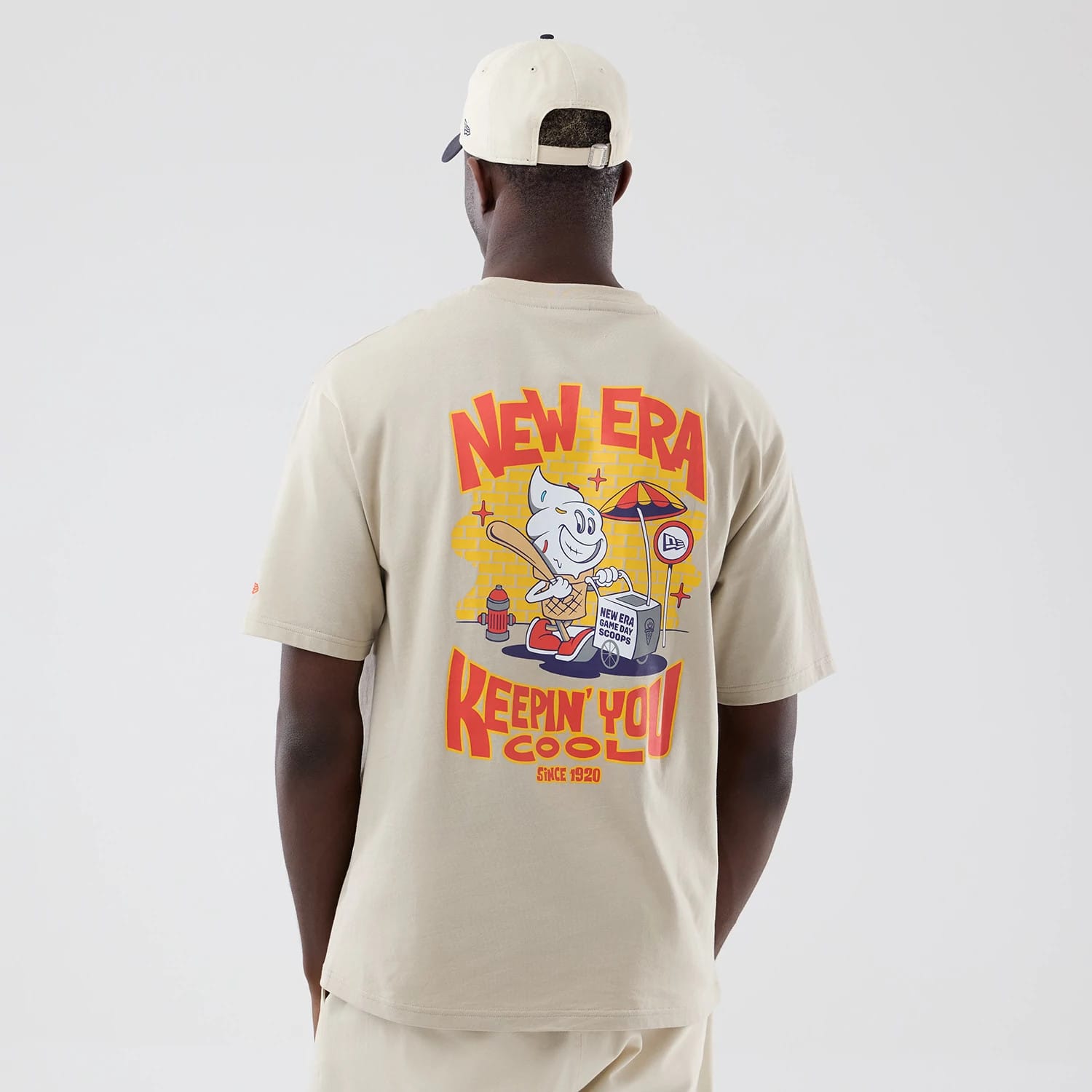 The model is wearing this New Era Food Graphic Oversized T-Shirt in light beige. 2