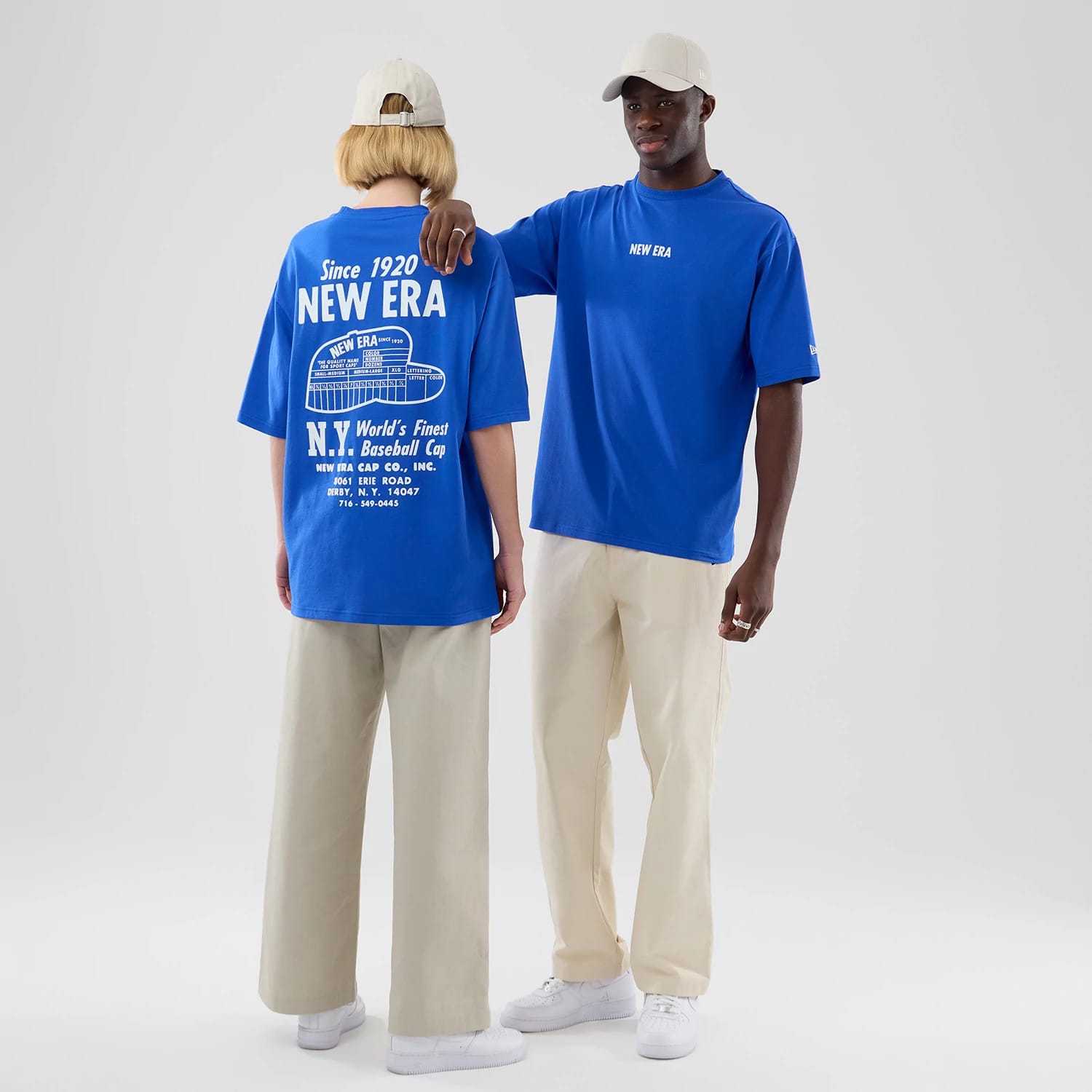 The model is wearing this New Era Cap Graphic Oversized T-Shirt in bright blue. 1