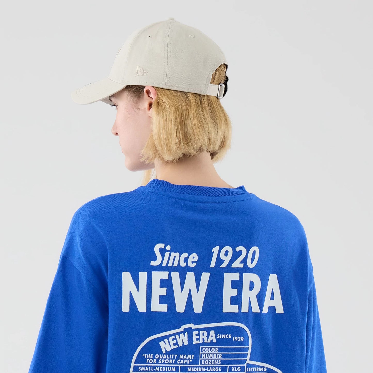 The model is wearing this New Era Cap Graphic Oversized T-Shirt in bright blue. 8