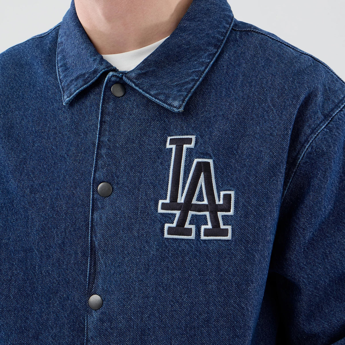 New Era LA Dodgers MLB Coaches Dark Blue Jacket, front view showing a dark blue jacket with a large embroidered LA Dodgers logo on the left chest, black snap buttons down the front and a classic collar above a white undershirt.