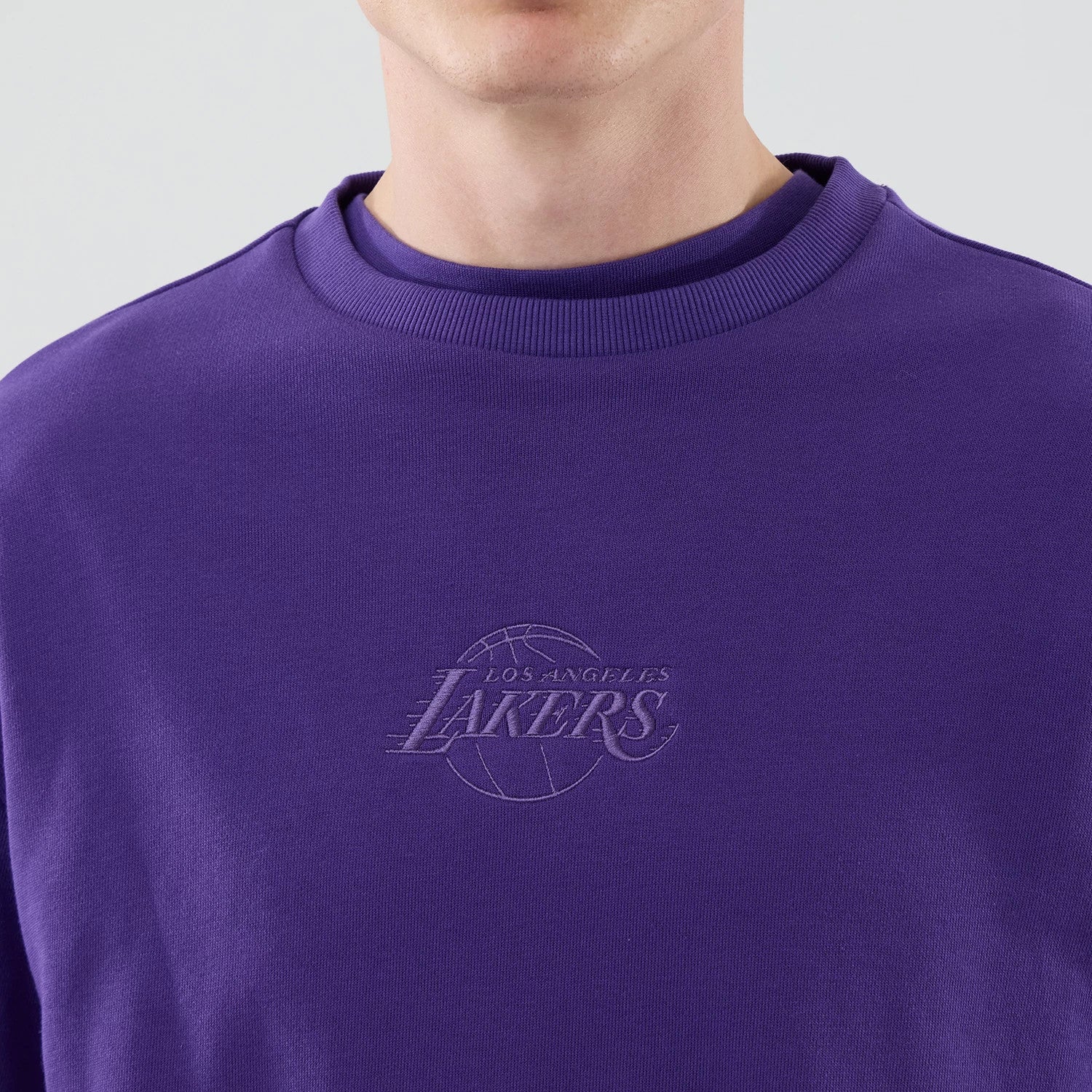 The model is wearing this NBA League Essential LA Lakers Oversized Crew Neck Sweater in purple. 4