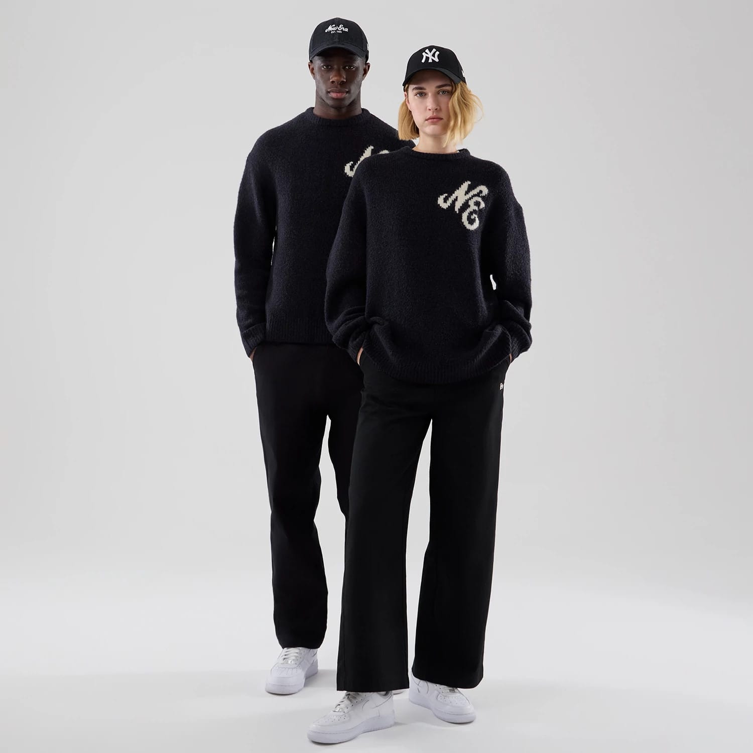 The model is wearing this New Era Knit Heritage Knitted Sweater in navy. 1