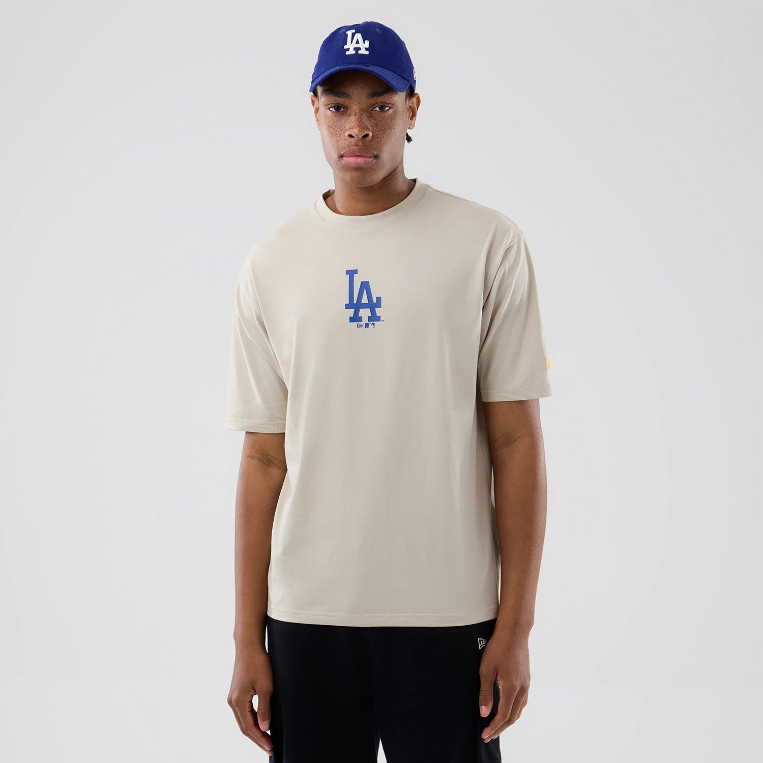 The model is wearing this MLB Food Graphic LA Dodgers Oversized T-Shirt in cream. 1