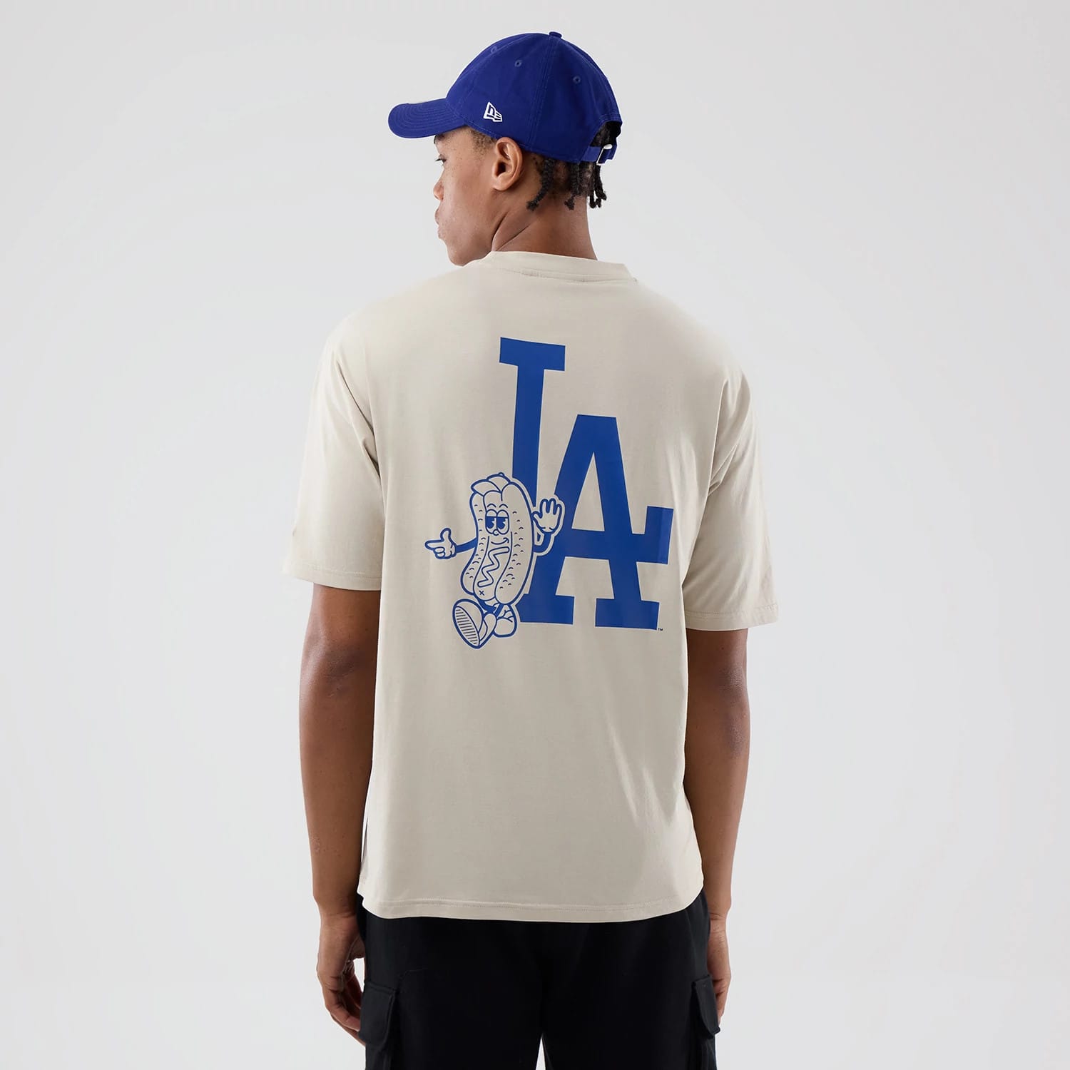 The model is wearing this MLB Food Graphic LA Dodgers Oversized T-Shirt in cream. 2